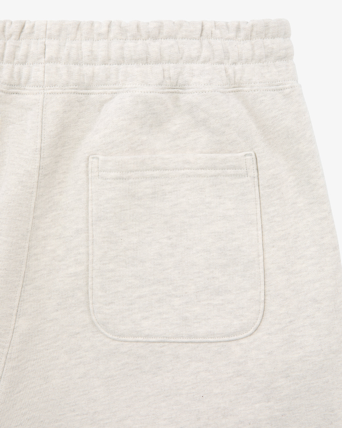 Close-up of the back pocket and elastic waistband on Tonal Logo Sweatpants in light beige.