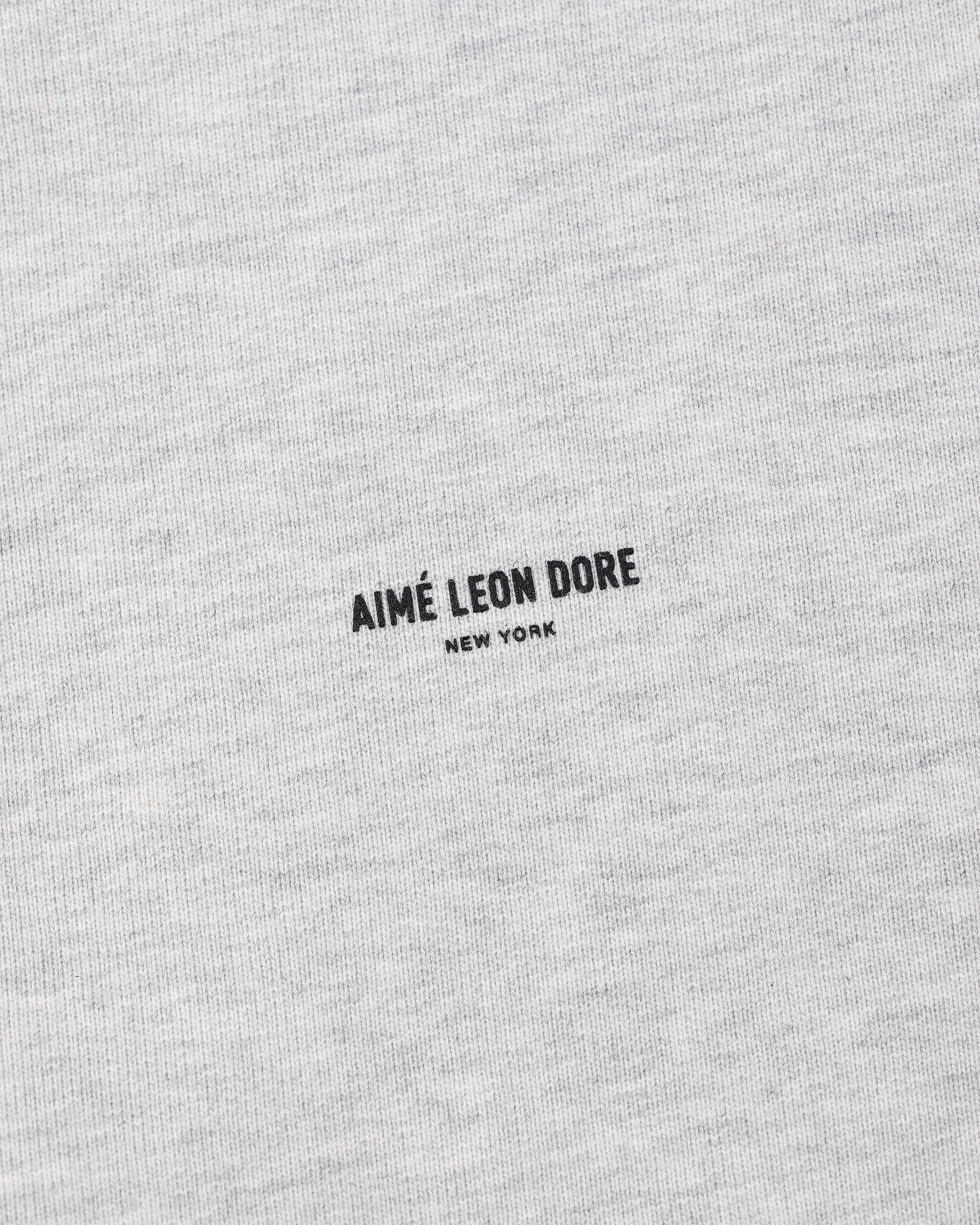 Close-up of a gray Micro Logo Crewneck Sweatshirt with AIMÉ LEON DORE NEW YORK printed in black at the center.