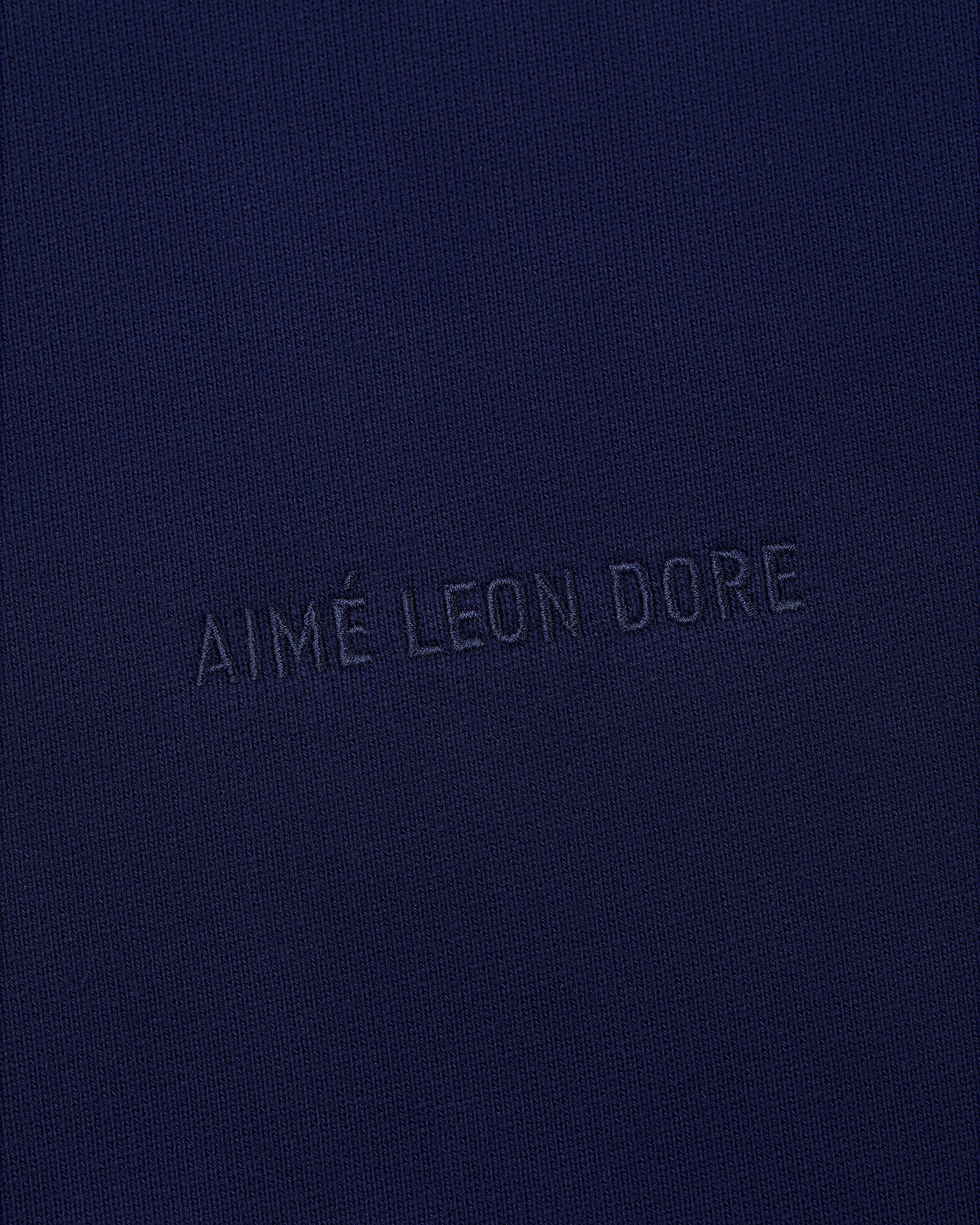 Close-up of navy blue fabric on the Tonal Logo Crewneck Sweatshirt with subtle matching embroidery.