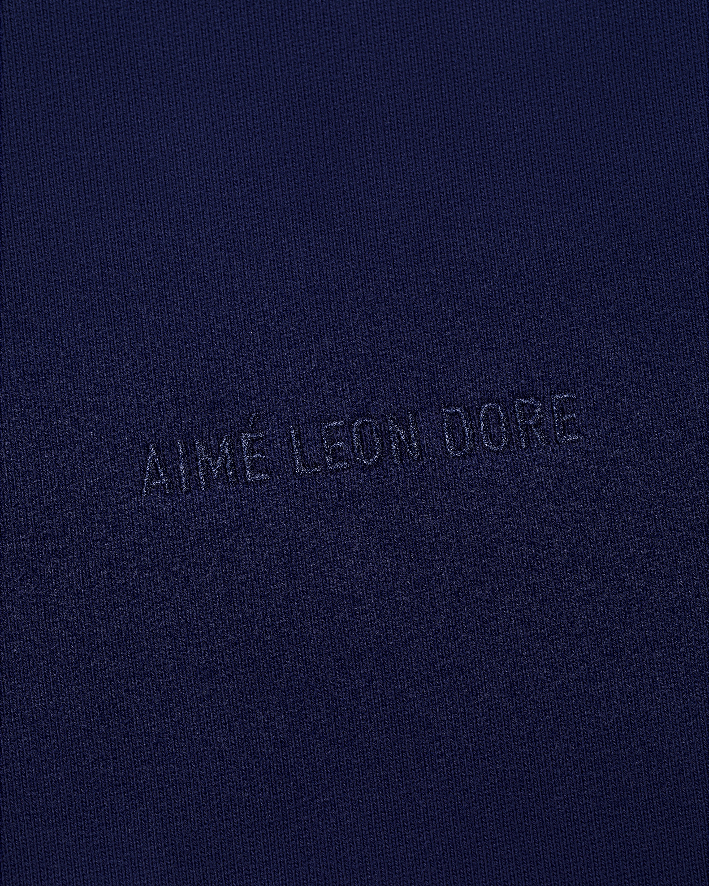 Close-up of navy blue fabric on the Tonal Logo Crewneck Sweatshirt with subtle matching embroidery.