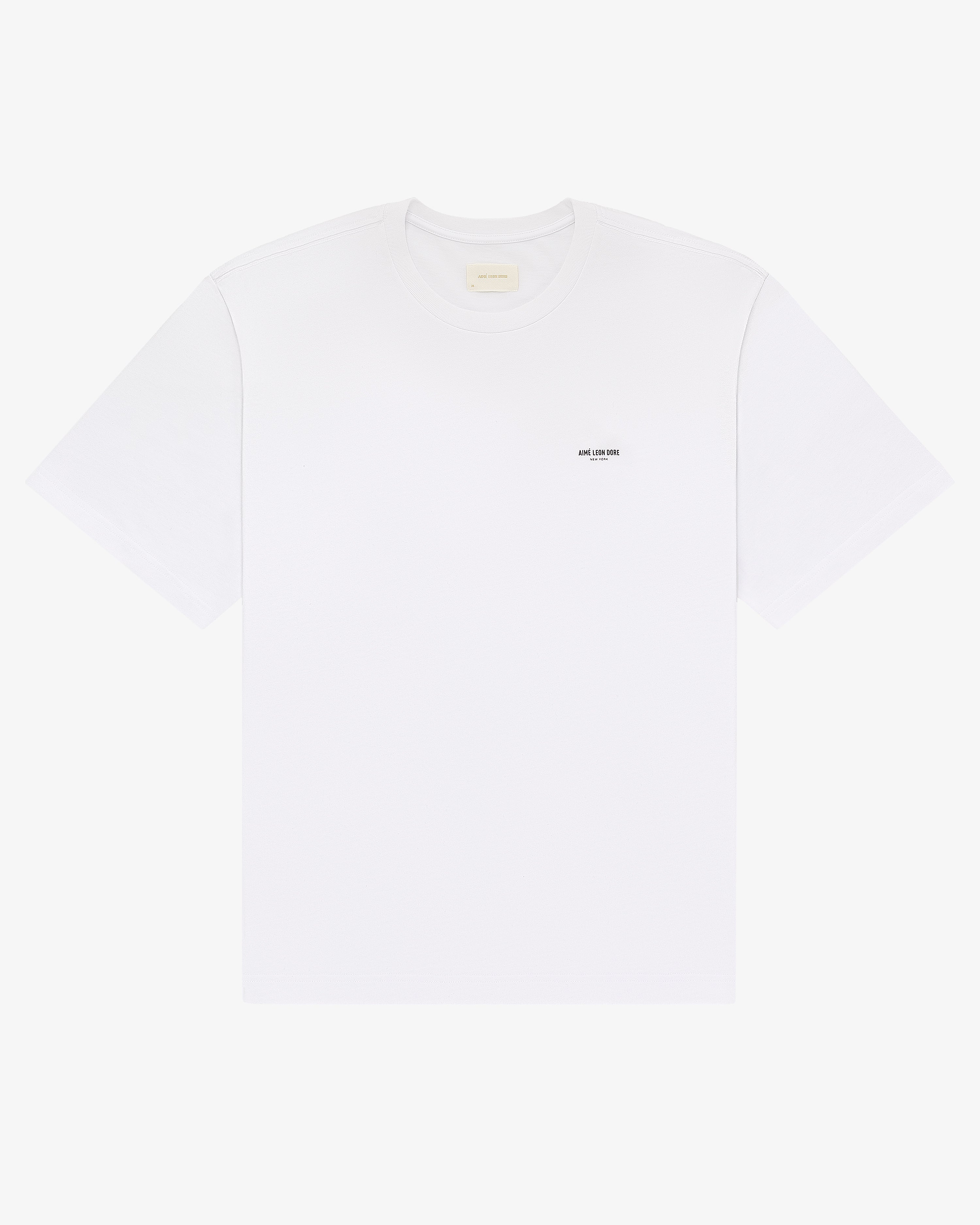 Micro Logo Tee: plain white short-sleeve t-shirt with a small black logo on the left chest.