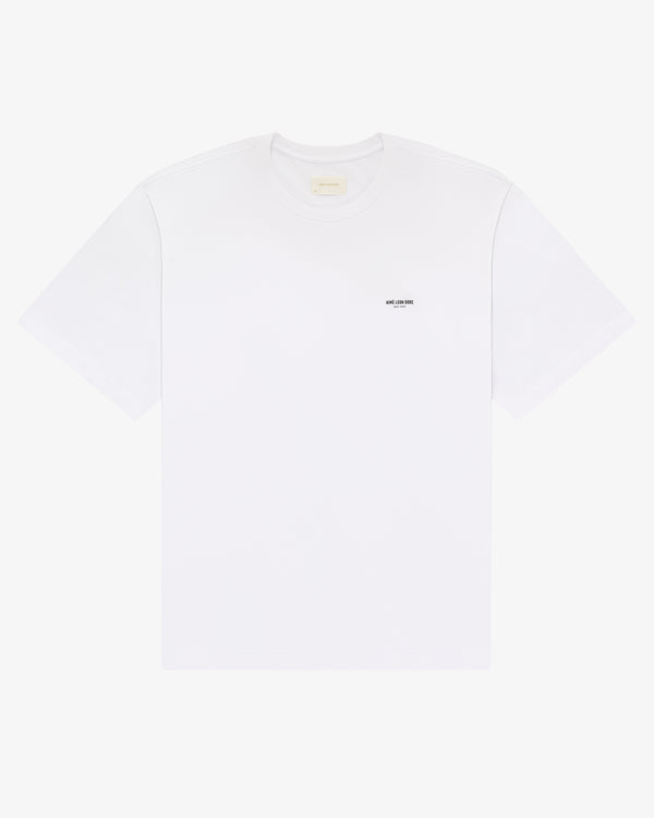 Micro Logo Tee: plain white short-sleeve t-shirt with a small black logo on the left chest.