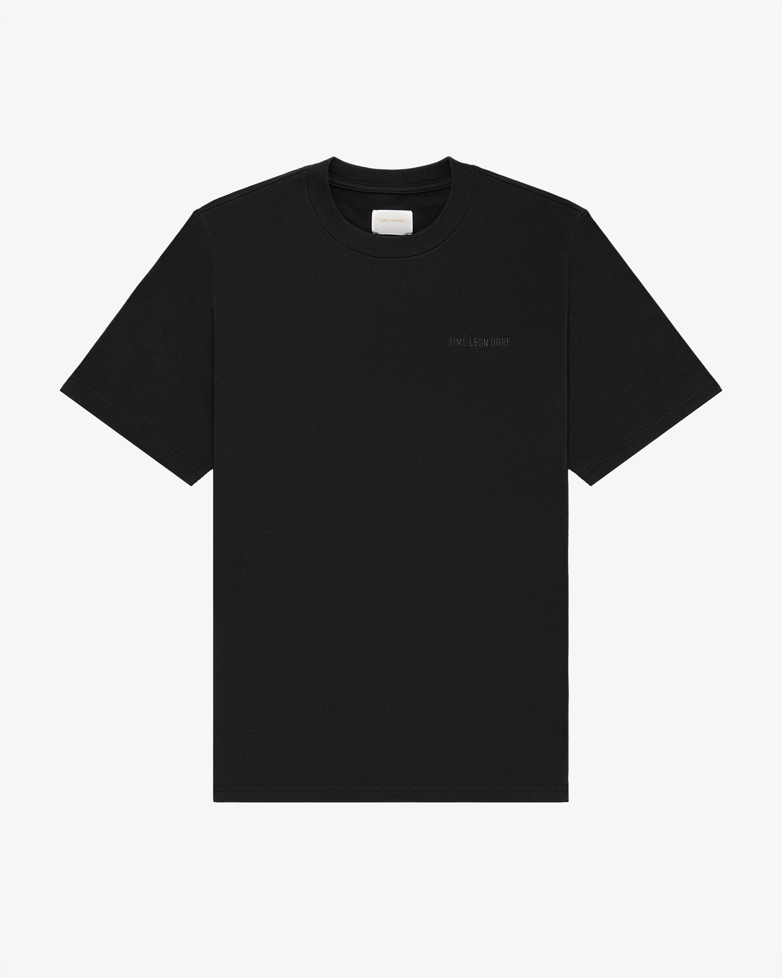 Tonal Logo Tee in plain black with subtle left chest text, short sleeves, shown on a white background.