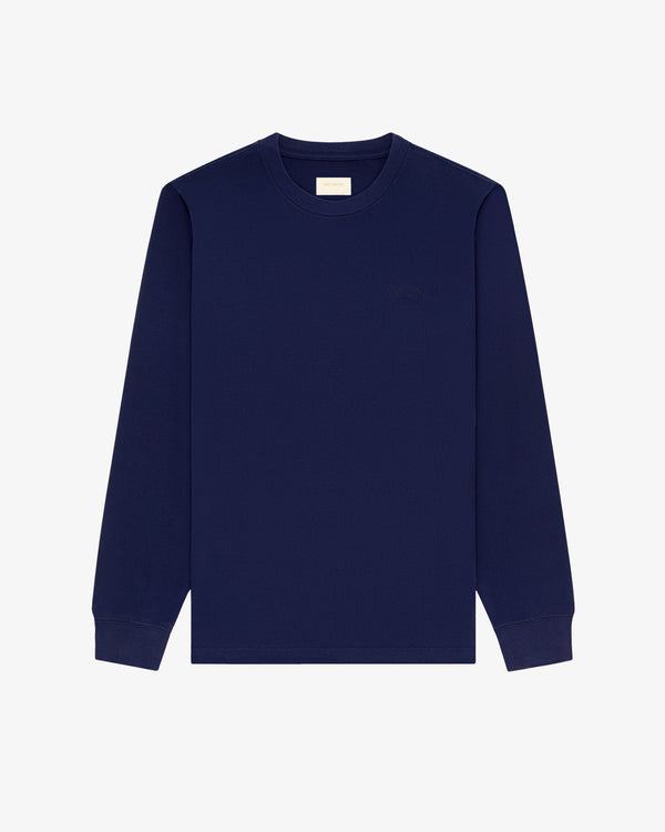 Long-Sleeve Tonal Logo Tee in navy blue with ribbed cuffs, displayed on a plain white background.