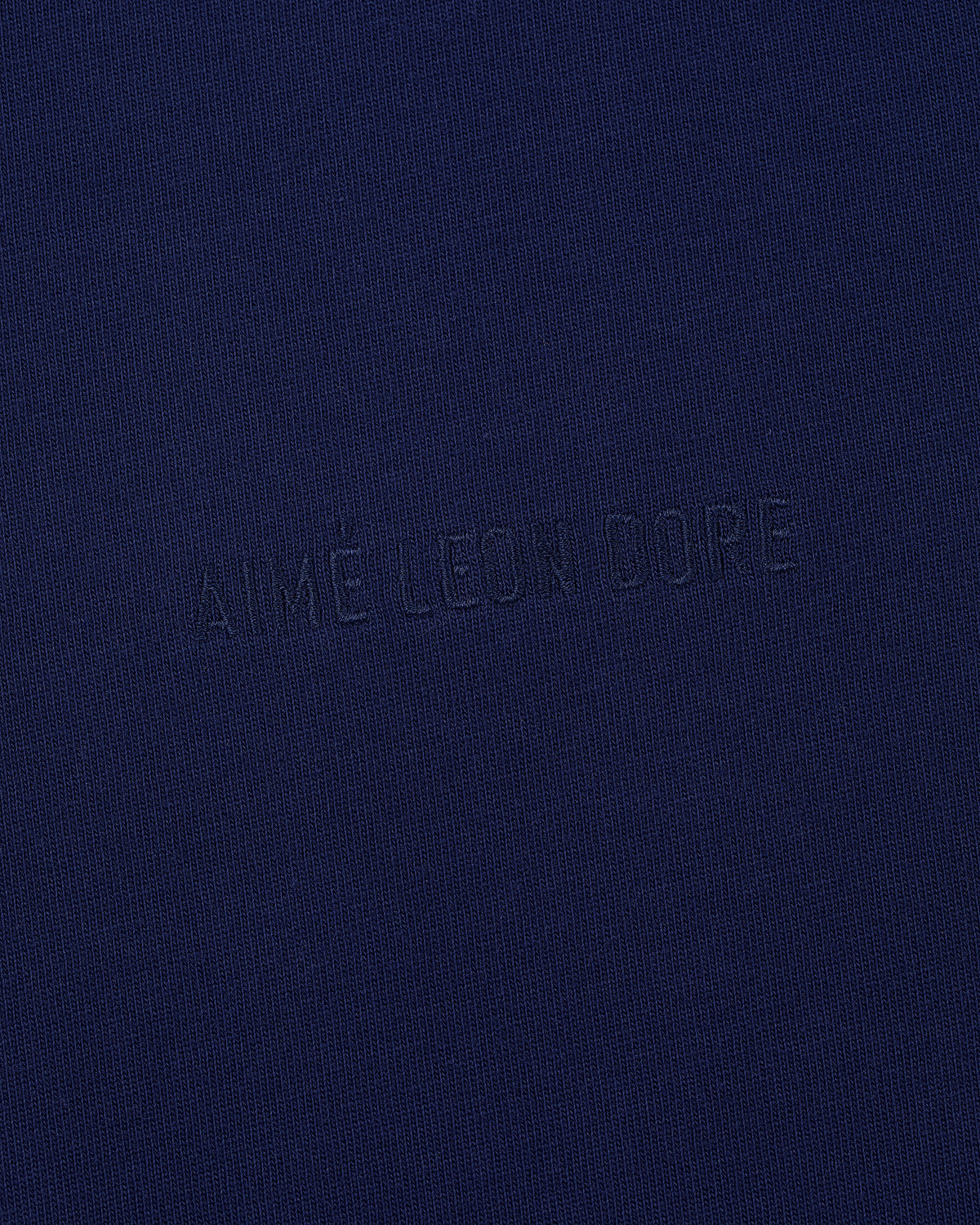 Navy blue Long-Sleeve Tonal Logo Tee with AIMÉ LEON DORE subtly embossed in the center.