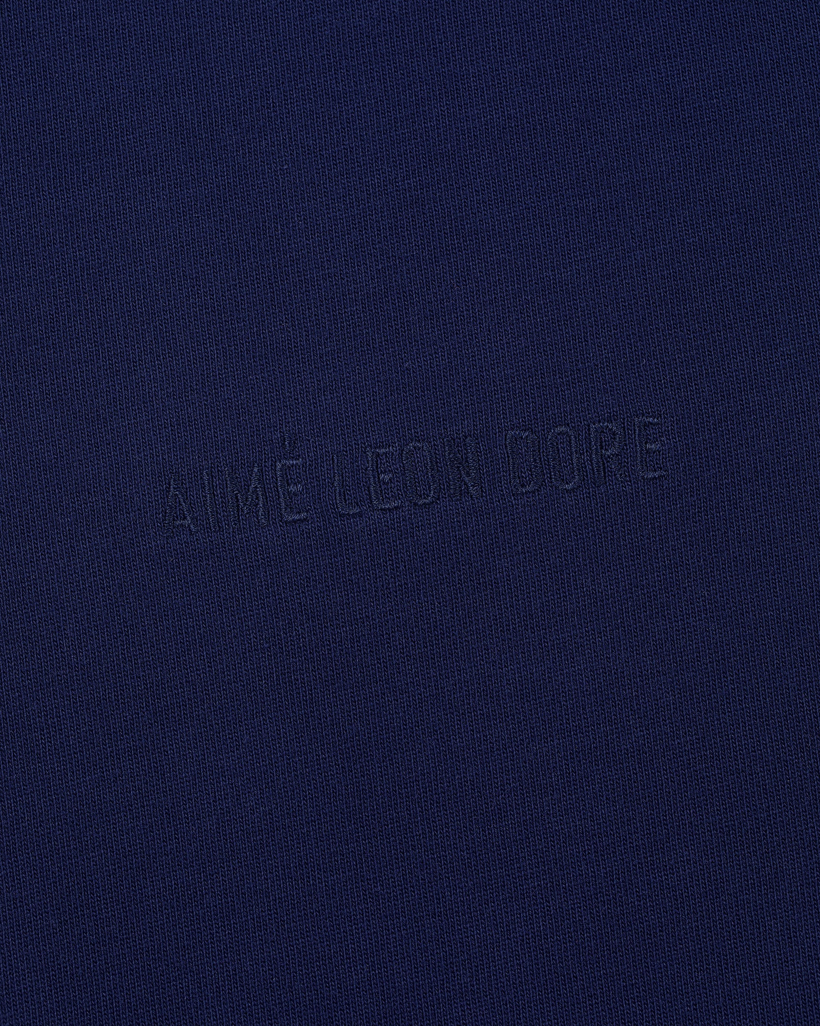 Navy blue Long-Sleeve Tonal Logo Tee with AIMÉ LEON DORE subtly embossed in the center.