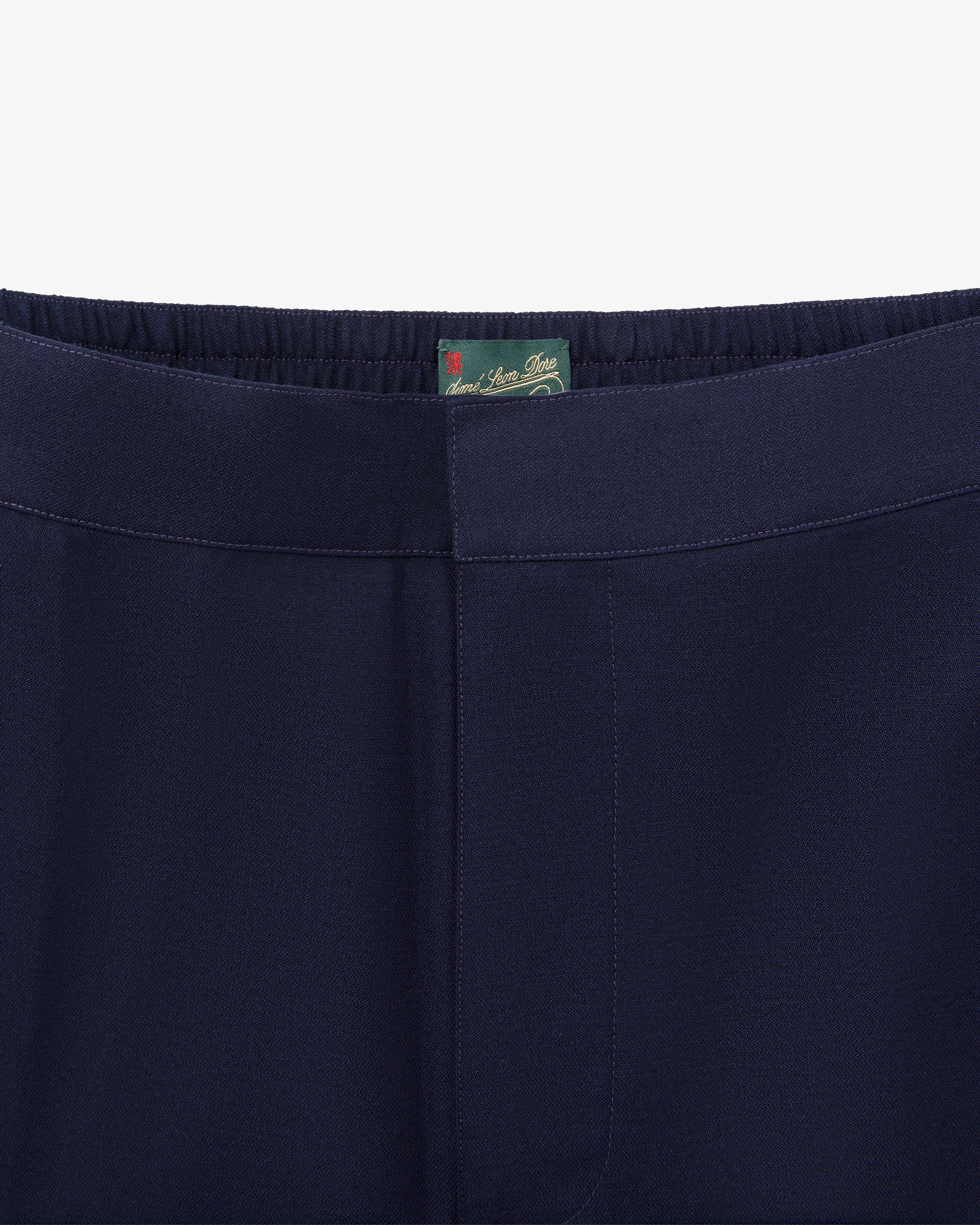 Close-up of waistband and upper part of Tropical Wool Elasticated Waist Suit Trouser in navy with a green inner tag.