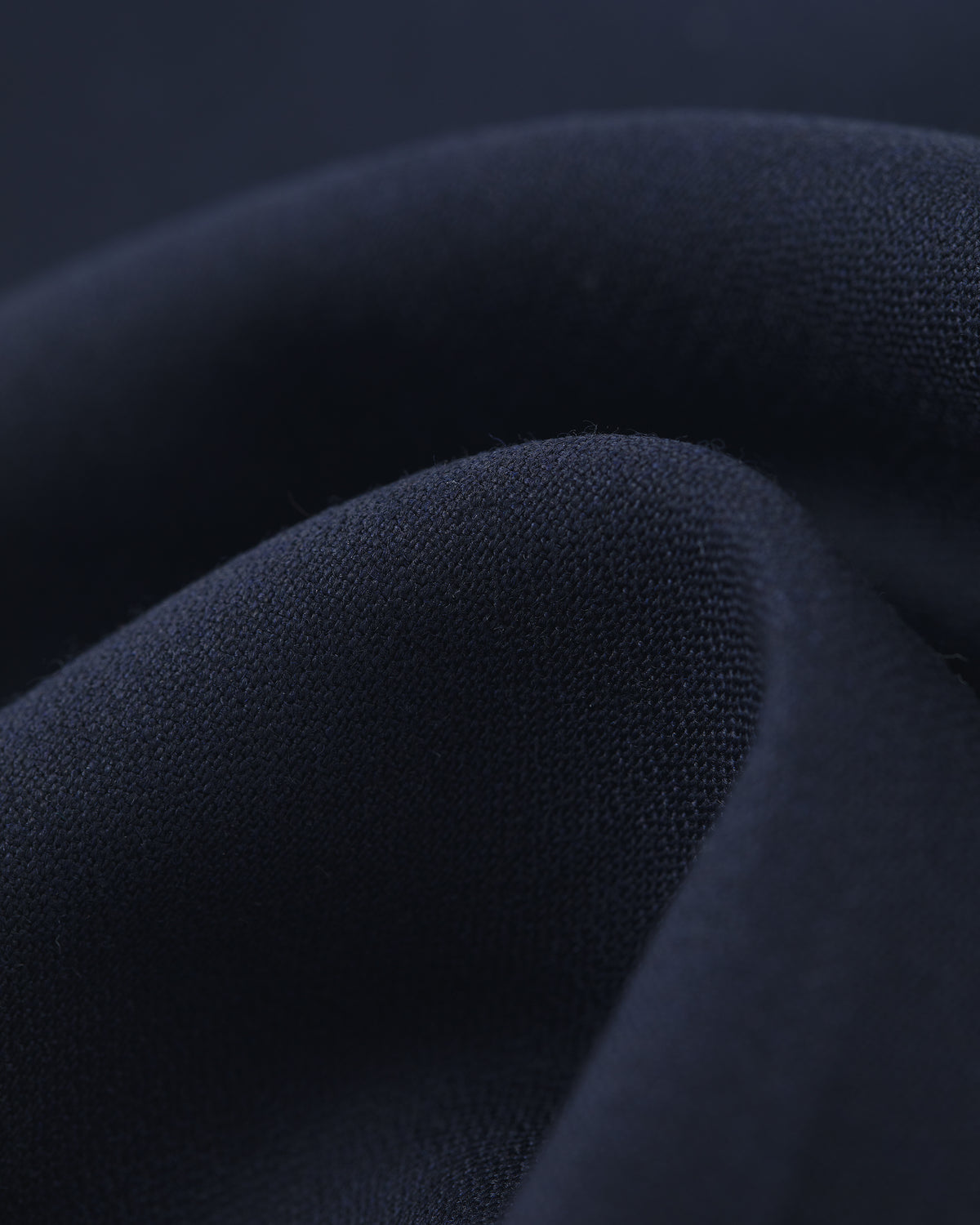 Close-up of Tropical Wool Elasticated Waist Suit Trouser in soft, dark navy fabric with smooth texture and gentle folds.