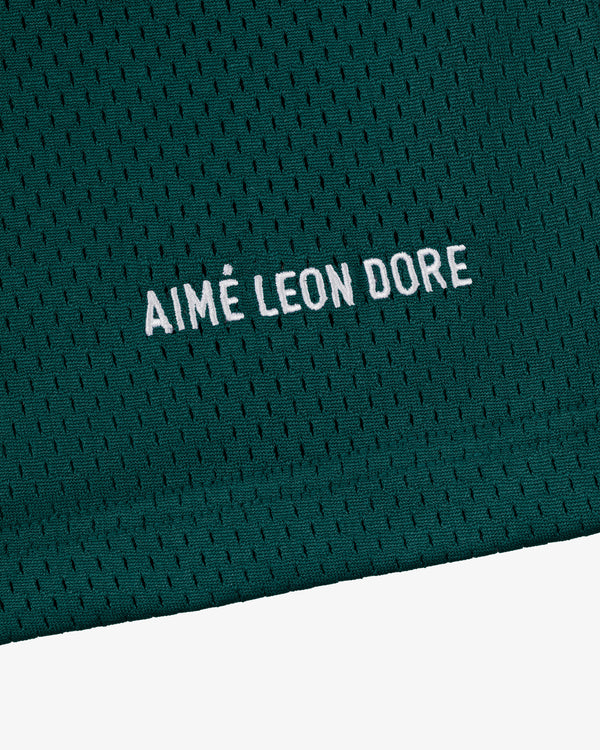 Close-up of green mesh Logo Gym Short with AIMÉ LEON DORE embroidered in white capital letters.