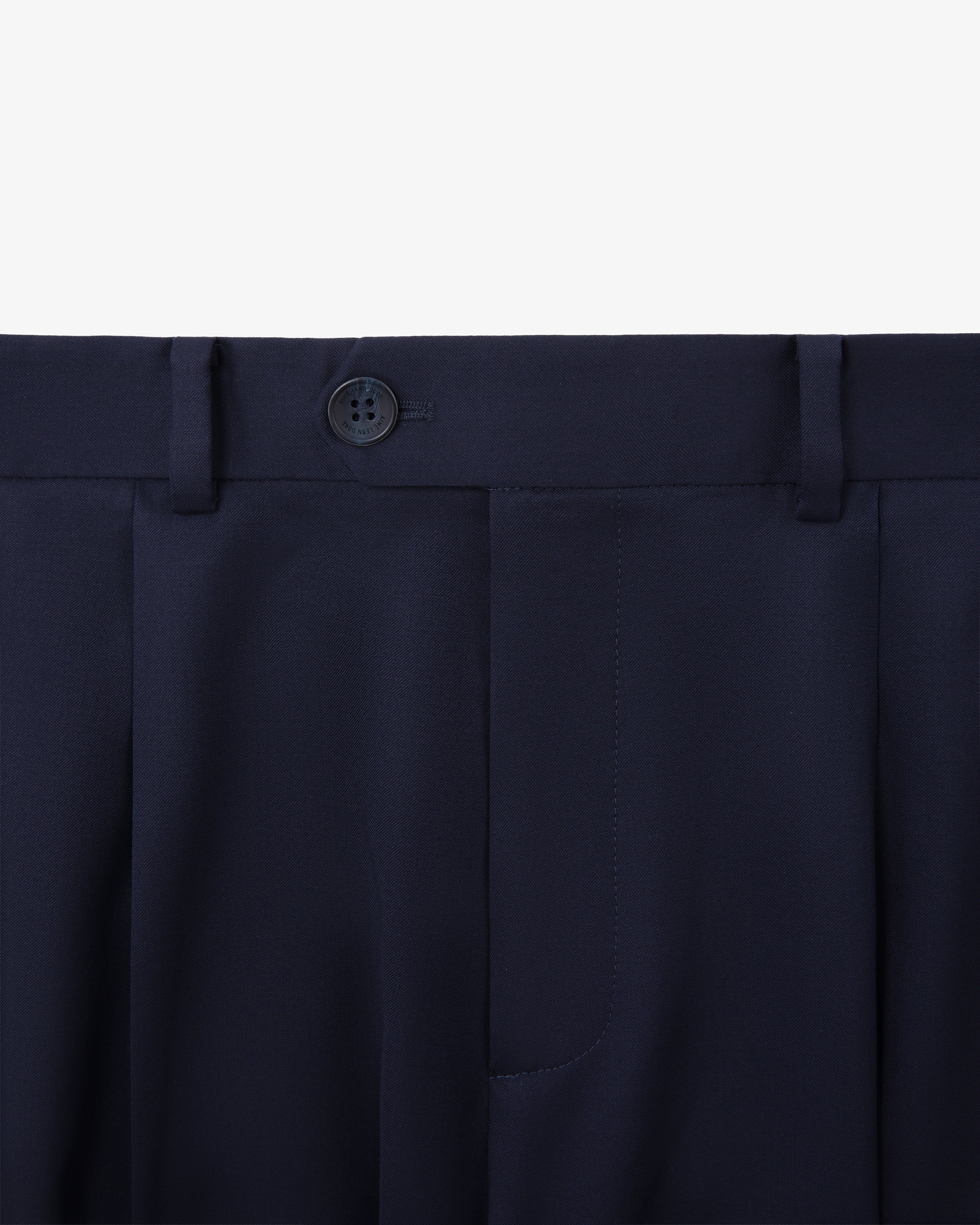Close-up of Single-Pleated Gabardine Trouser in navy with button and belt loops on a white background.