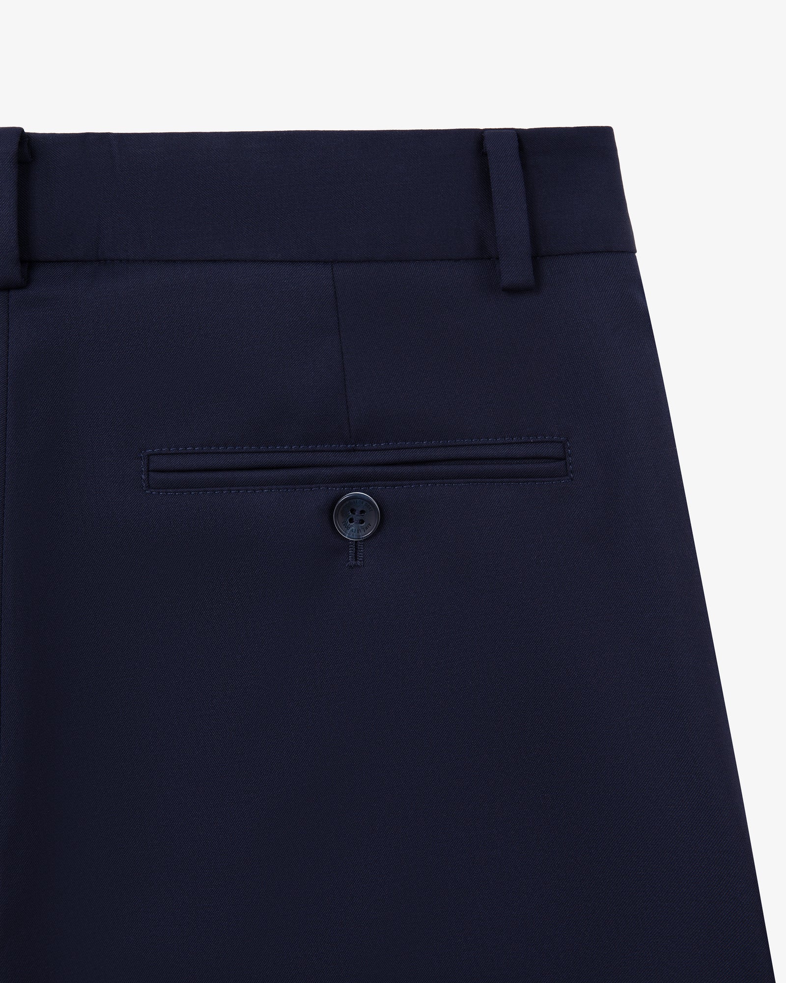 Close-up of Single-Pleated Gabardine Trouser in navy with back pocket, button, and belt loops on white background.