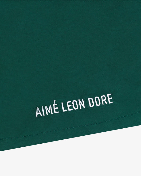Green Core Nylon Short with white AIMÉ LEON DORE embroidery in a minimalist style near the bottom edge.