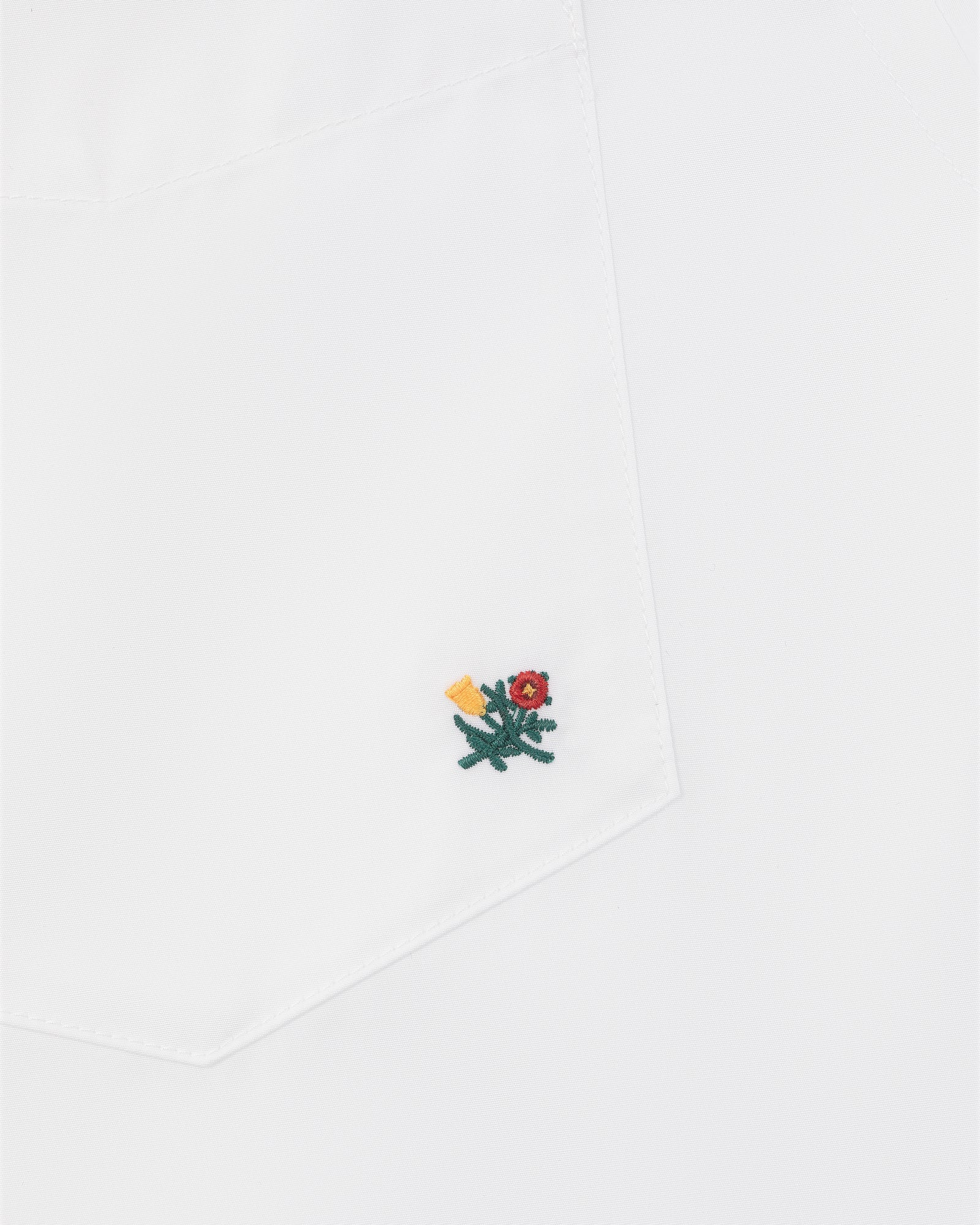 Crest Oxford Shirt with white pocket, small green flower embroidery, red center, and yellow detail near the corner.