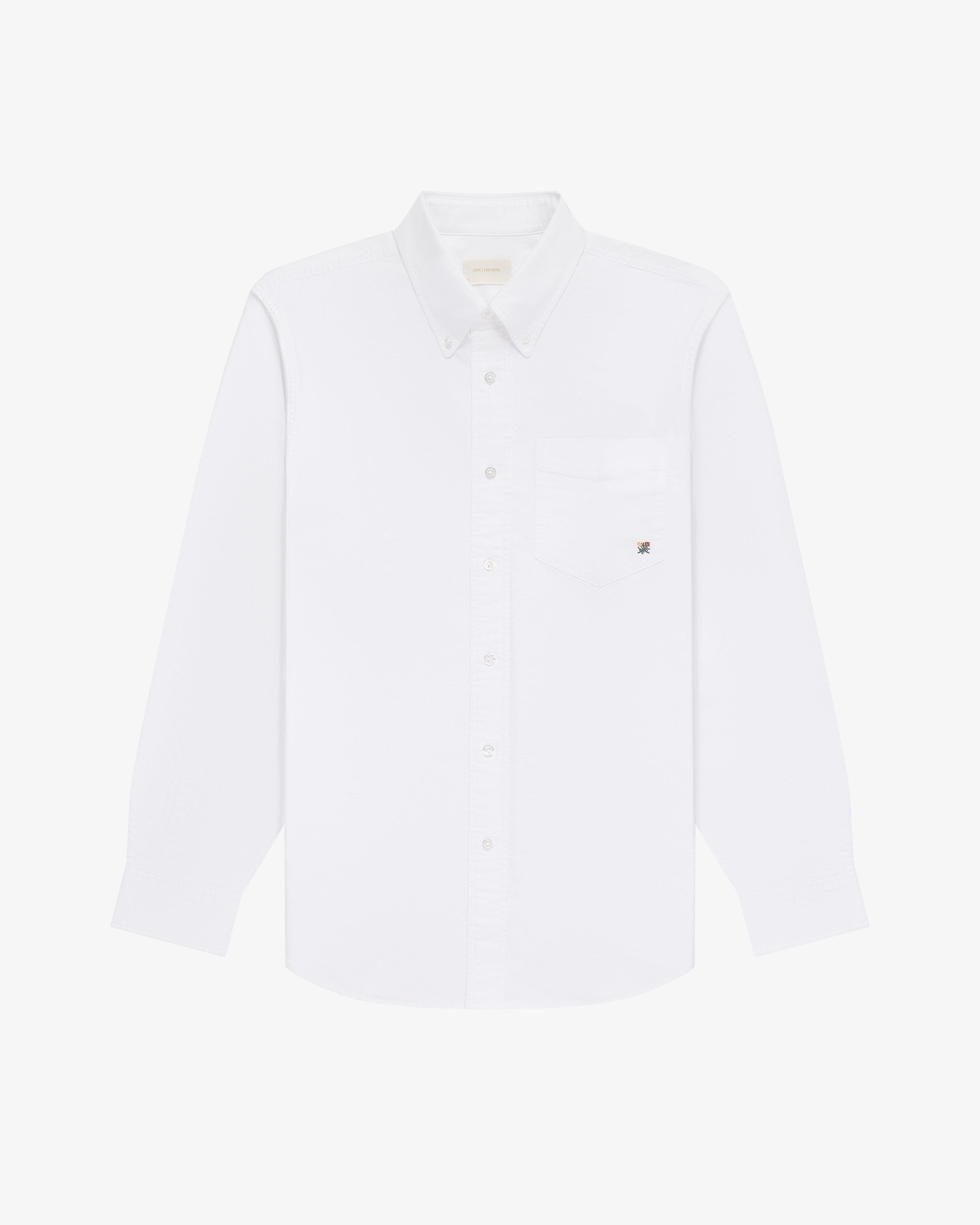 The Crest Oxford Shirt: a white, long-sleeve button-up with chest pocket, shown on a white background.