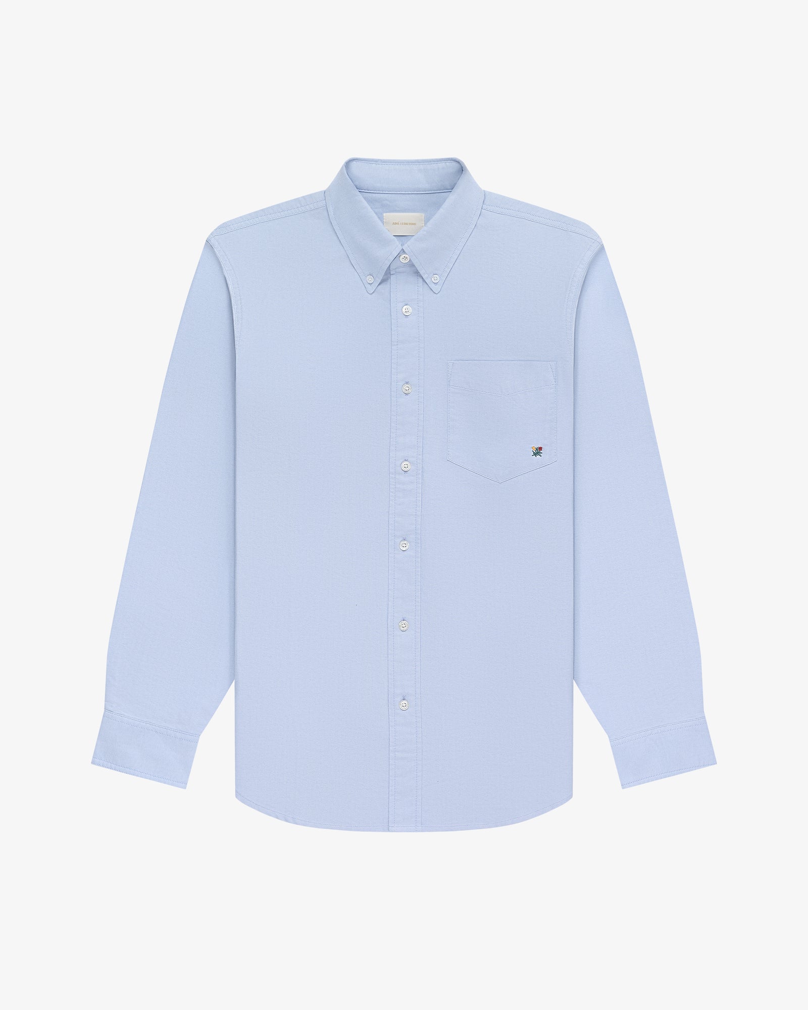 Crest Oxford Shirt in light blue, long sleeves, button-up with chest pocket, on a white background.