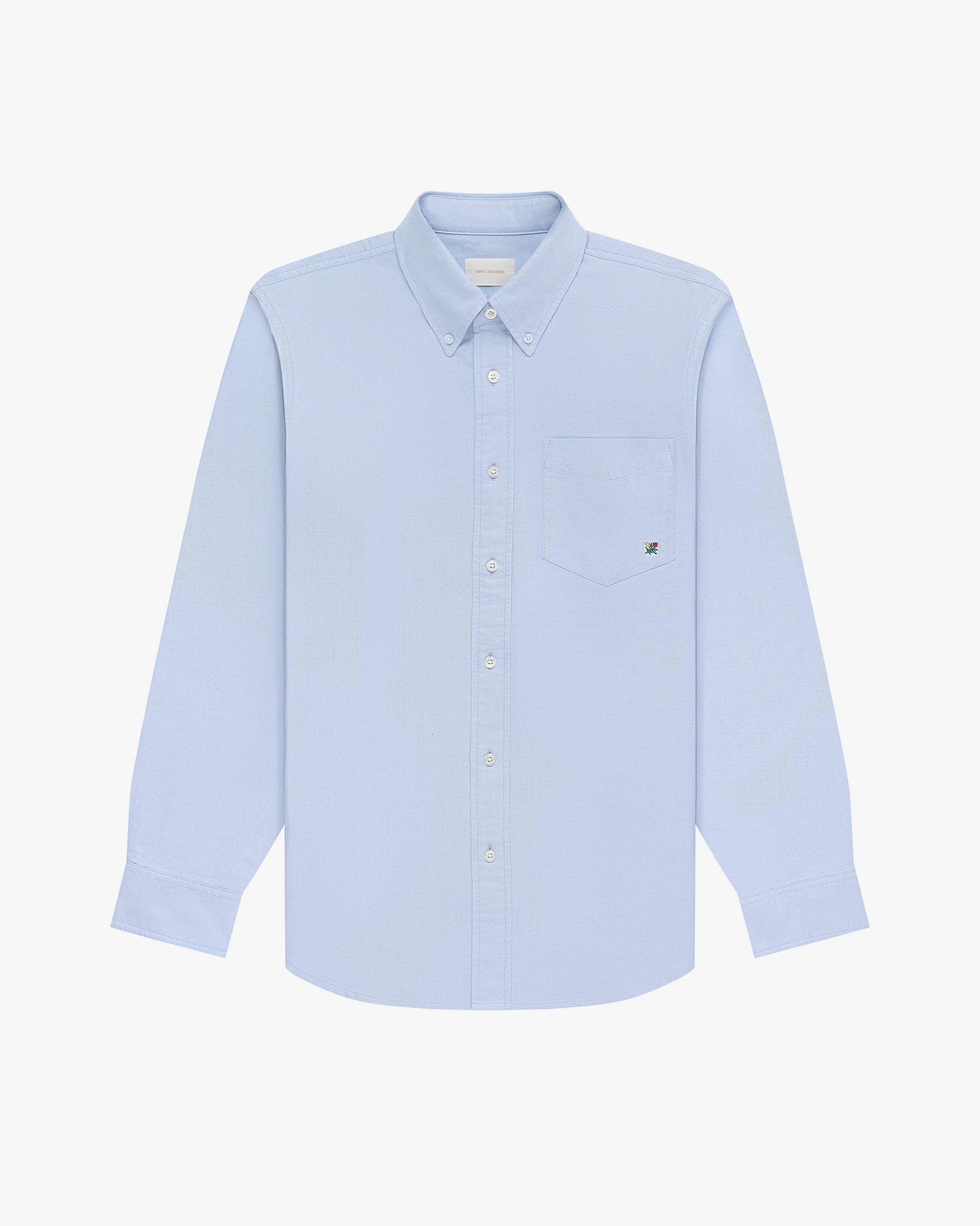 Crest Oxford Shirt in light blue, long sleeves, button-up with chest pocket, on a white background.