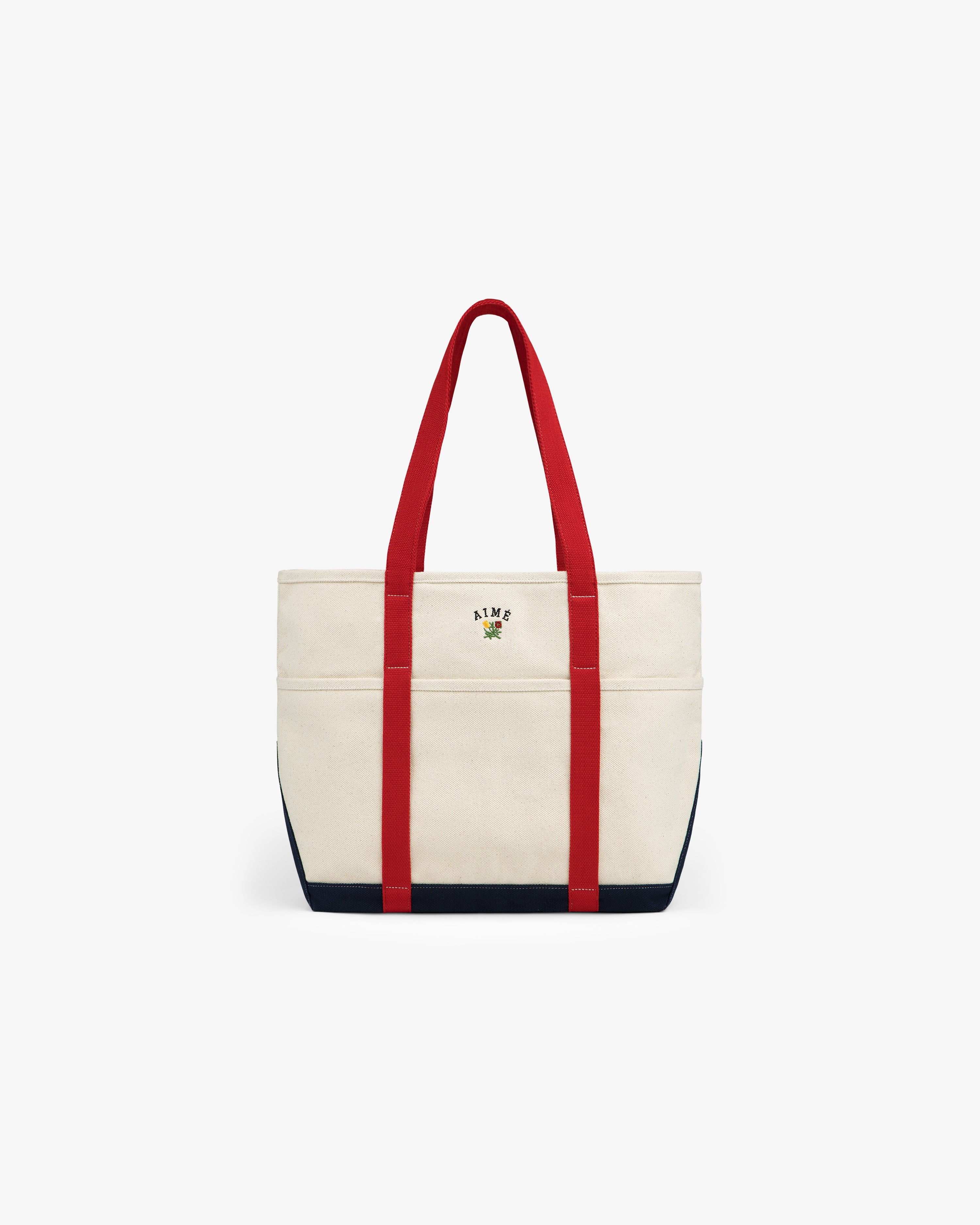 Large Crest Contrast Tote Bag with red handles, navy trim, and small floral ALME logo embroidered on the front.