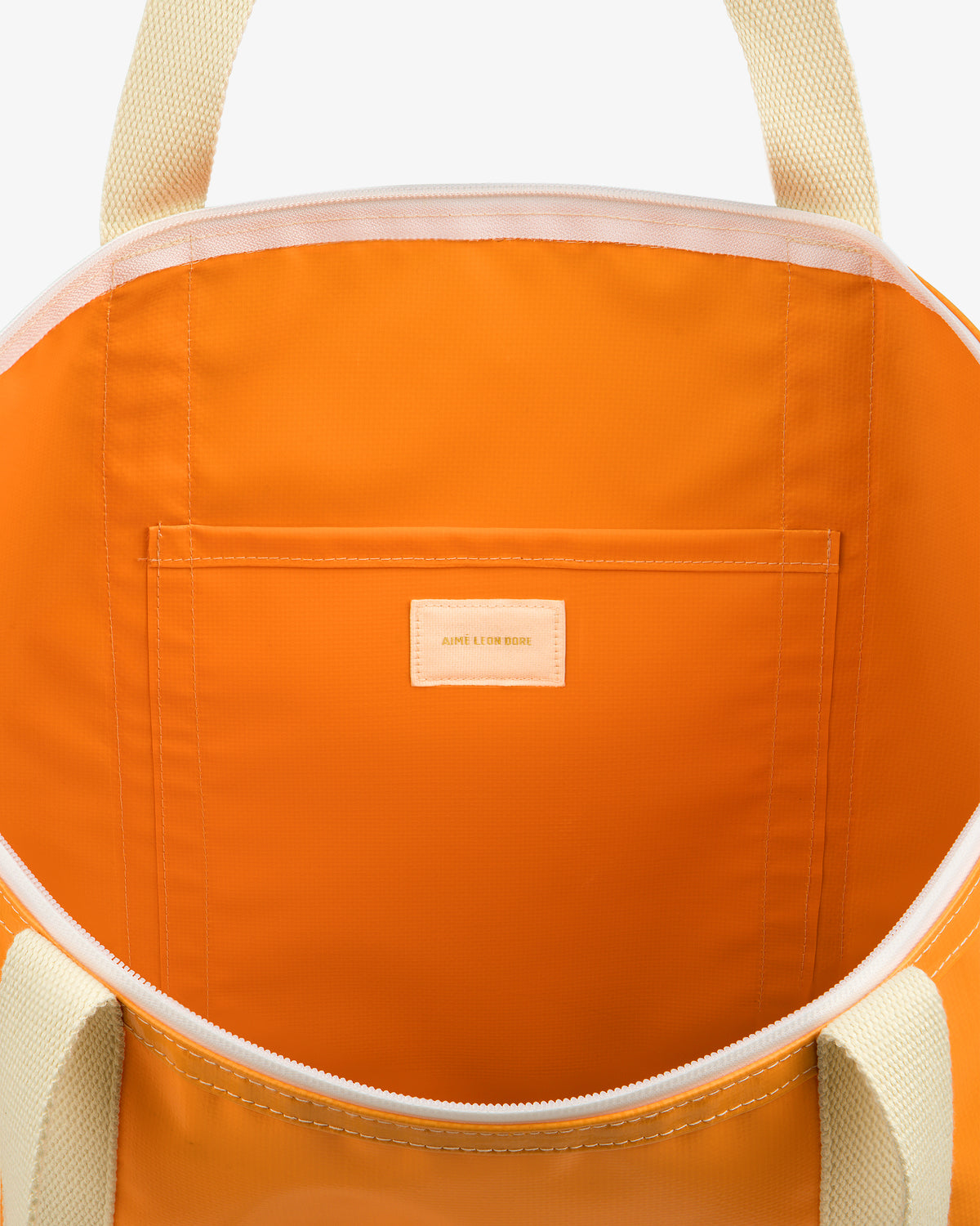 Open Carryall Marina Tote in orange with cream handles, featuring an inner pocket and AIME LEON DORE label.
