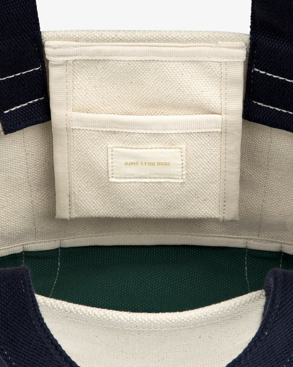 Interior of the Mini Crest Contrast Tote Bag with a small pocket and gold-stitched AIME LEON DORE label.