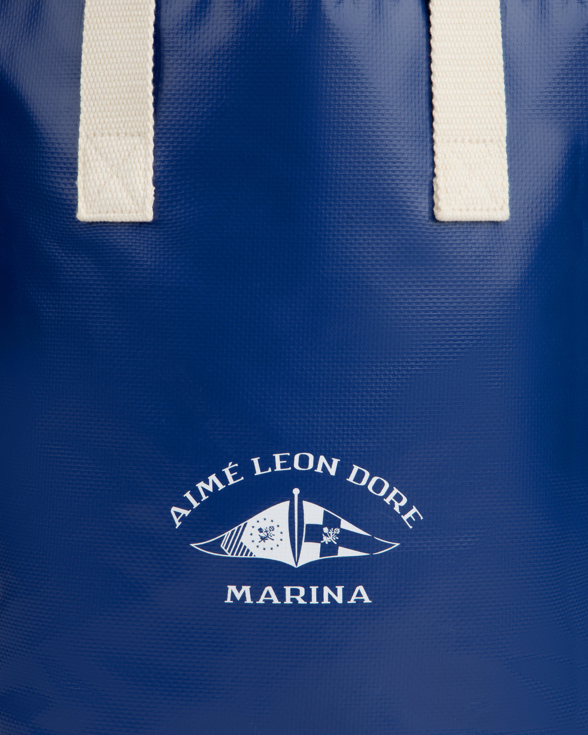 Blue Marina Bottle Tote with white handles and AIMÉ LEON DORE MARINA flag logo printed on the front.