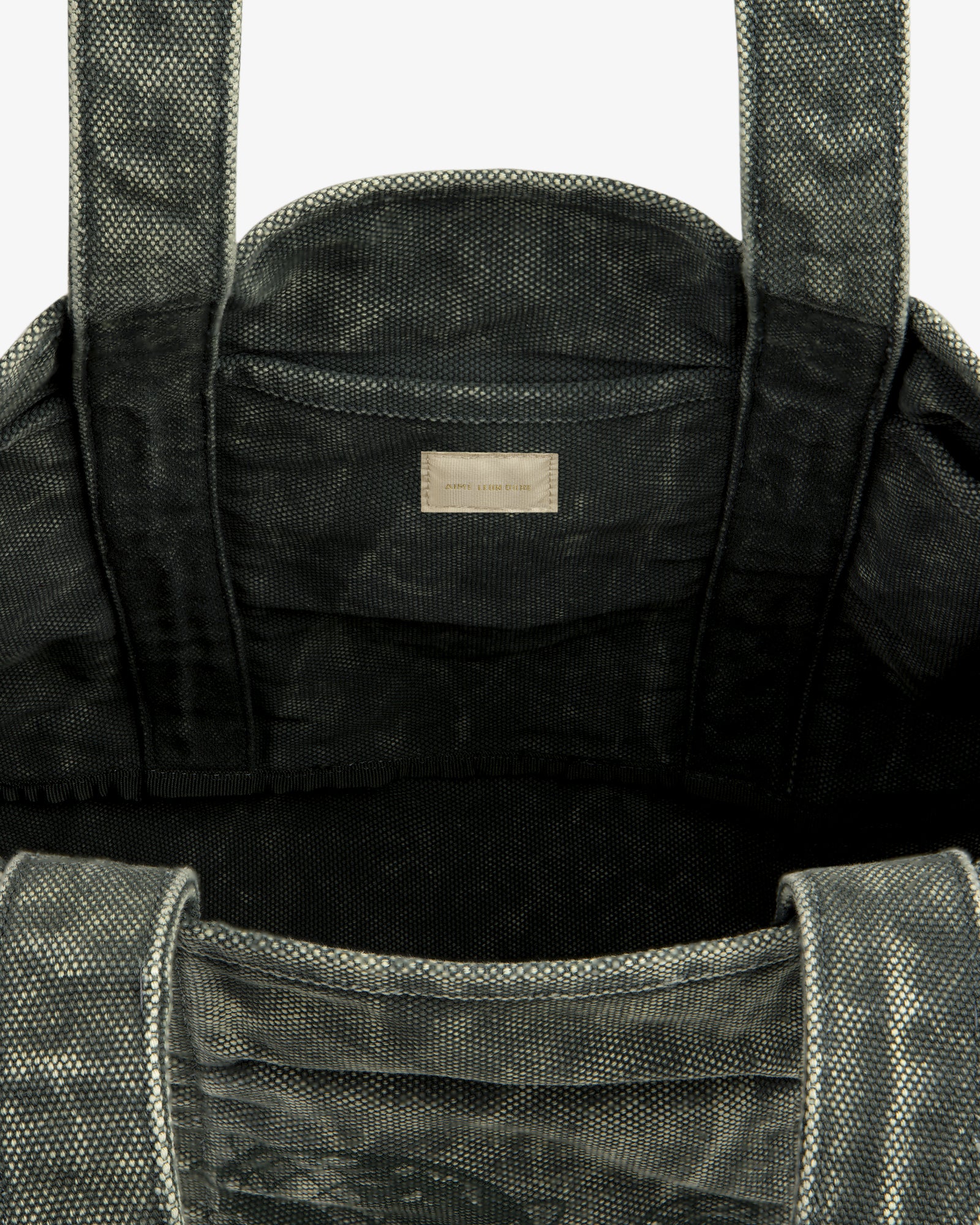 Close-up of the Sun Faded Large Unisphere Tote Bag's textured gray interior with handles and a small inside label.