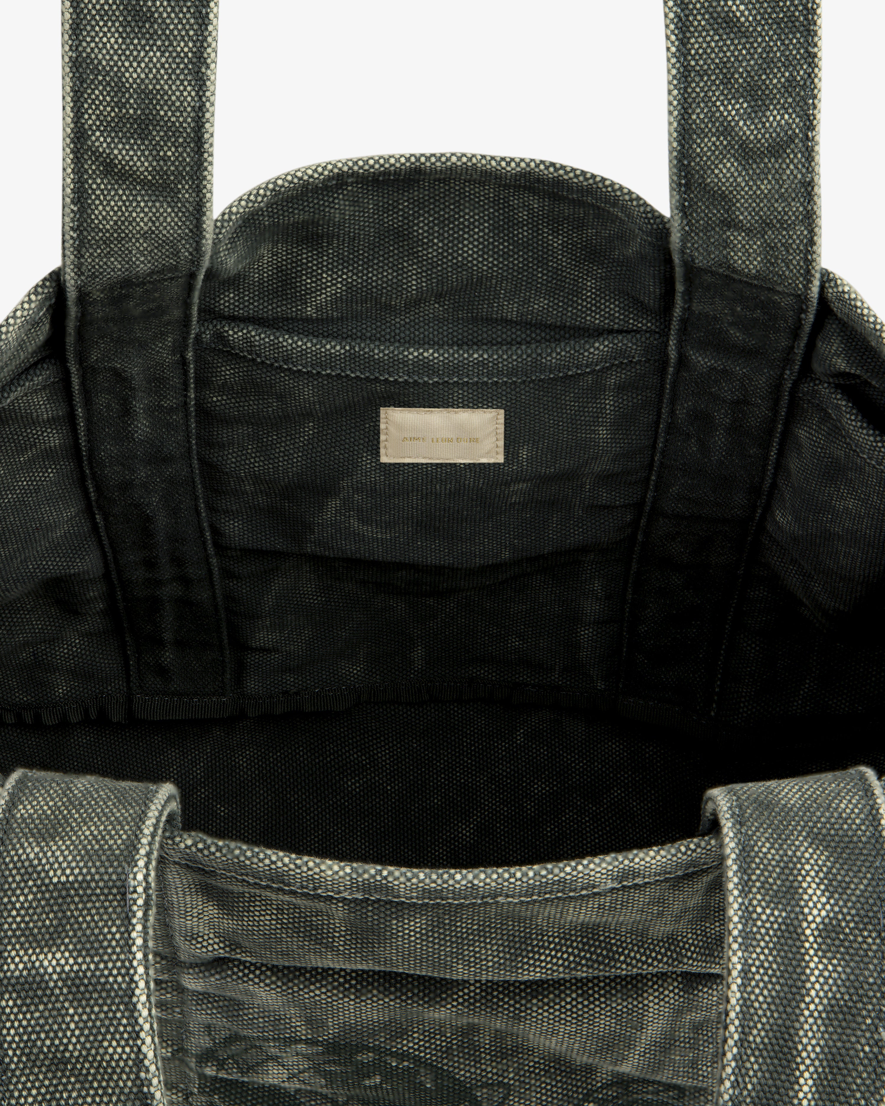 Close-up of the Sun Faded Large Unisphere Tote Bag's textured gray interior with handles and a small inside label.