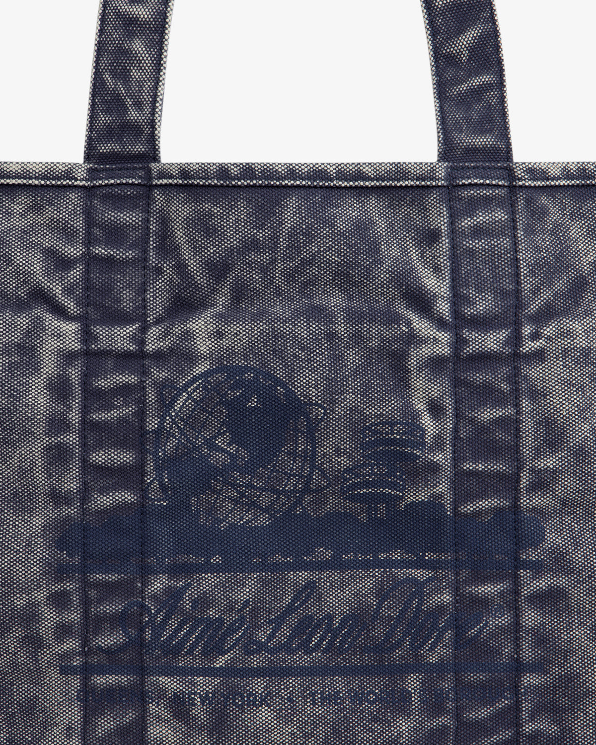 Close-up of the Sun Faded Large Unisphere Tote Bag, featuring a blue textured finish, handles, and a subtle front design.