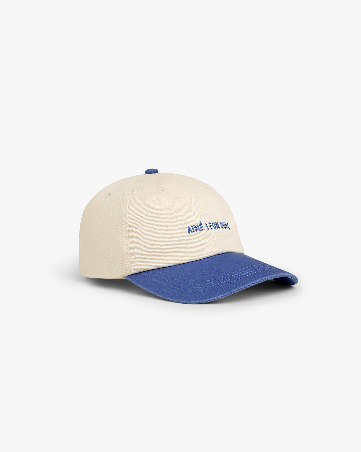Washed Chino Hat: Beige baseball cap with blue brim and "AIMÉ LEON DORE" embroidered in blue on the front.