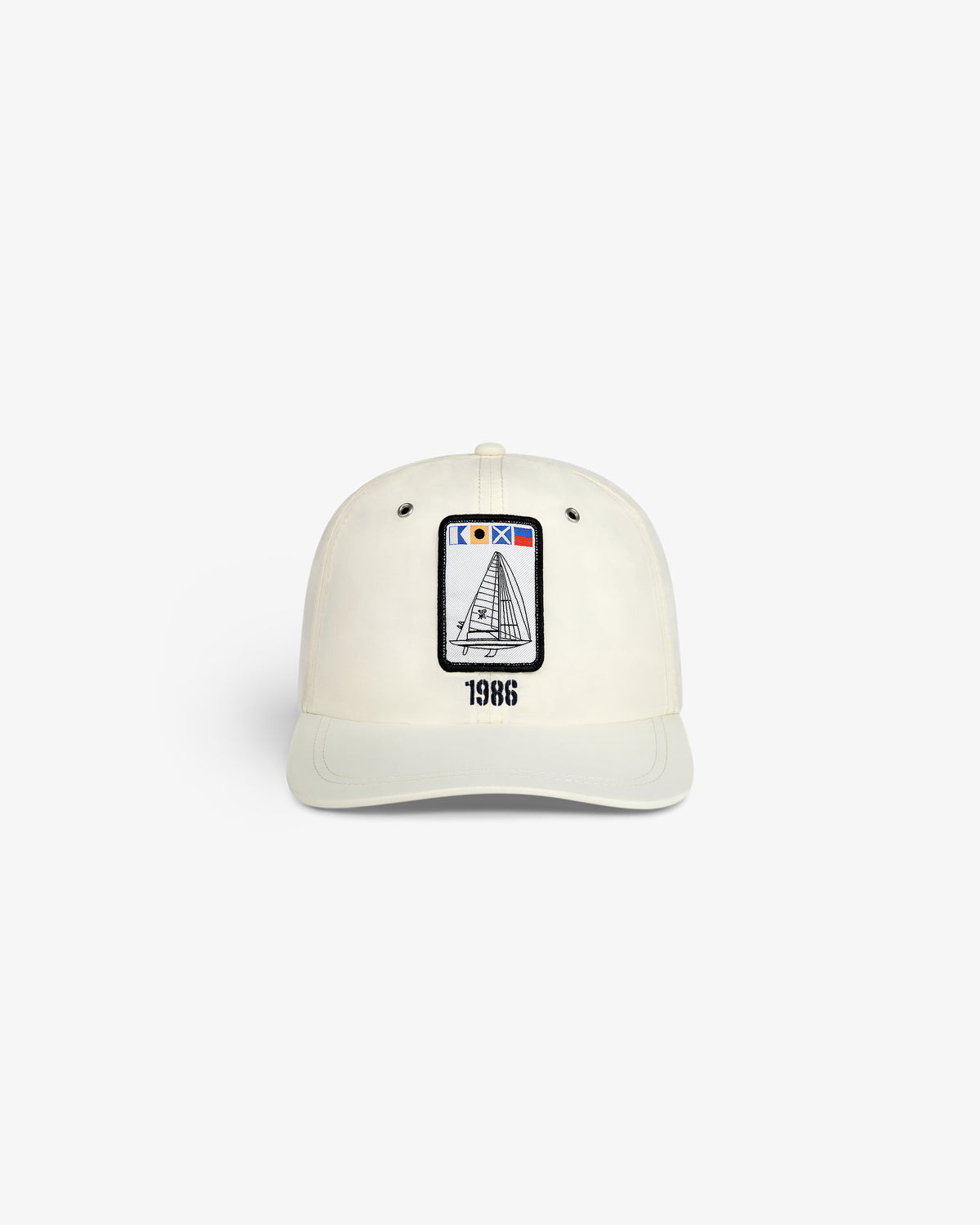 The Nylon Deck Hat is a white baseball cap with an embroidered sailboat patch and "1986" printed below it on the front.
