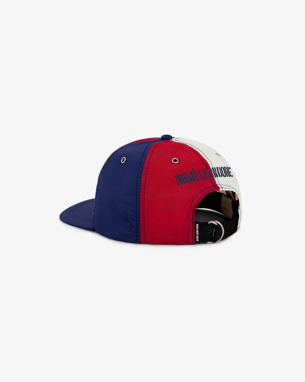 The Nylon Deck Hat is a color-blocked cap in blue, red, and white with an adjustable strap and side embroidery.