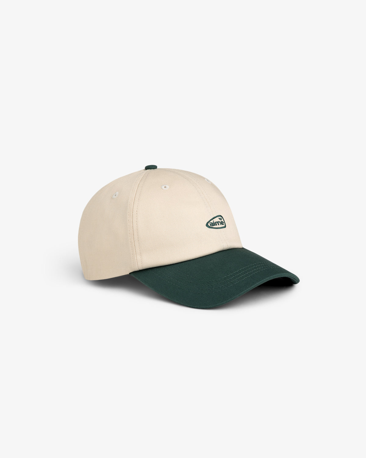 ALD Golf Logo Hat in beige with a dark green brim and small oval logo on front, displayed on white background.