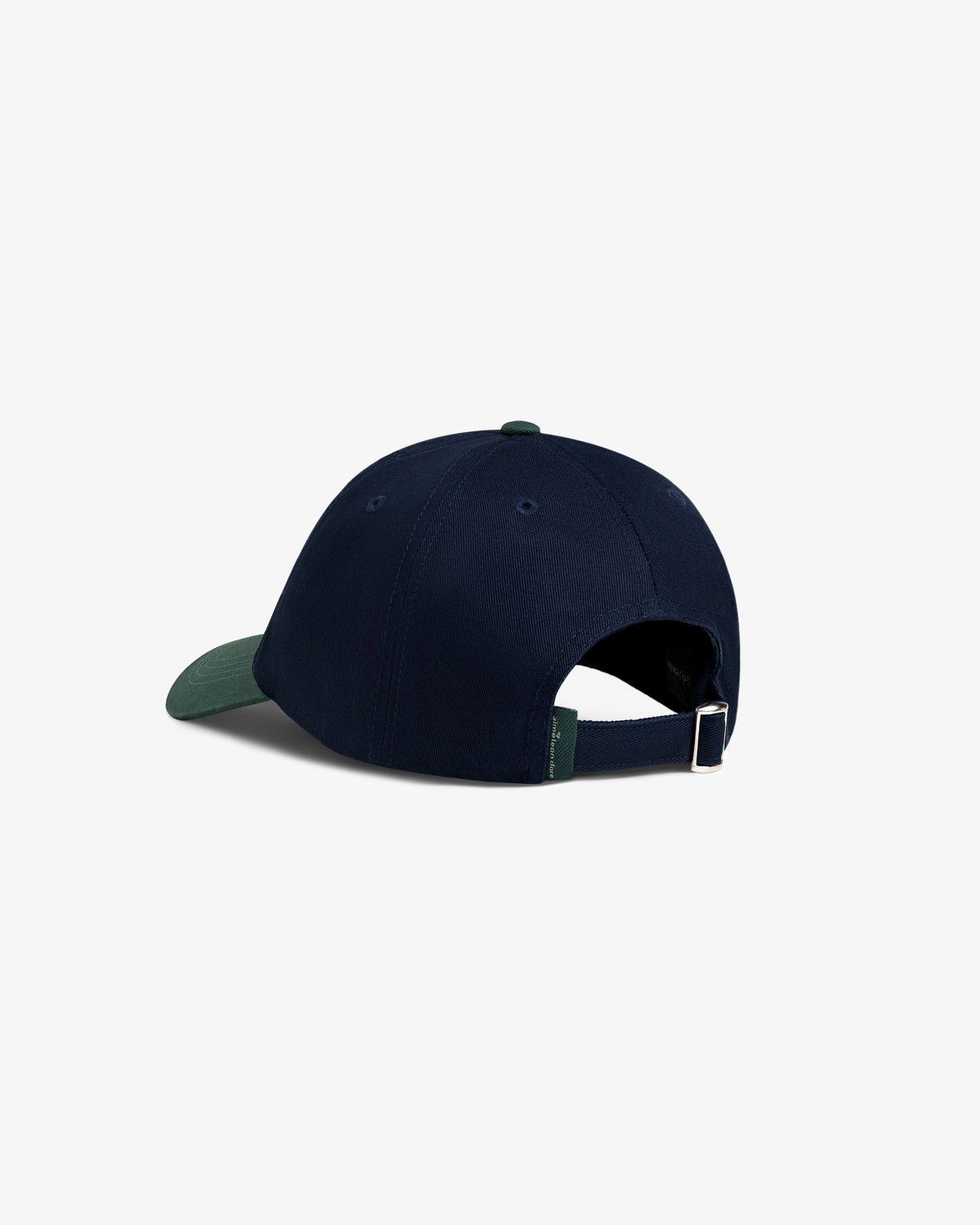 The ALD Golf Logo Hat in navy blue features a green brim, adjustable strap, and metal buckle at the back.