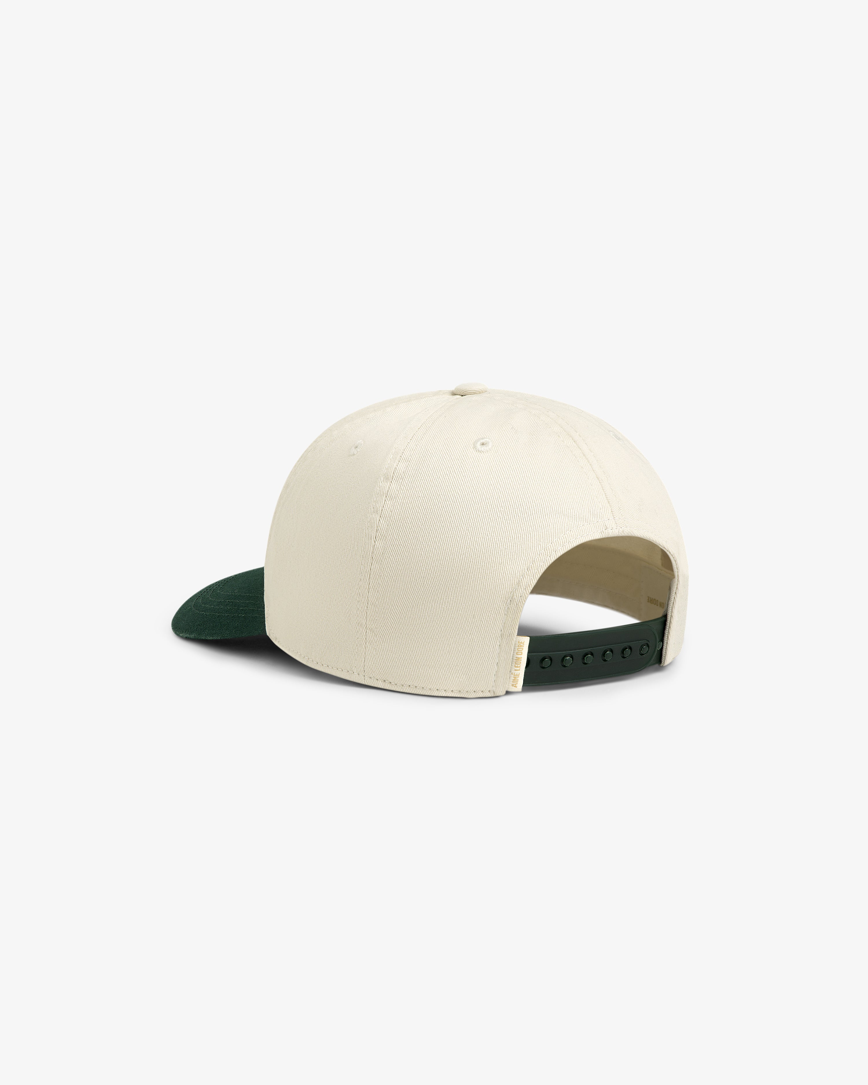 The Micro Logo Hat is cream-colored with a dark green brim, shown from the back with an adjustable snap closure.