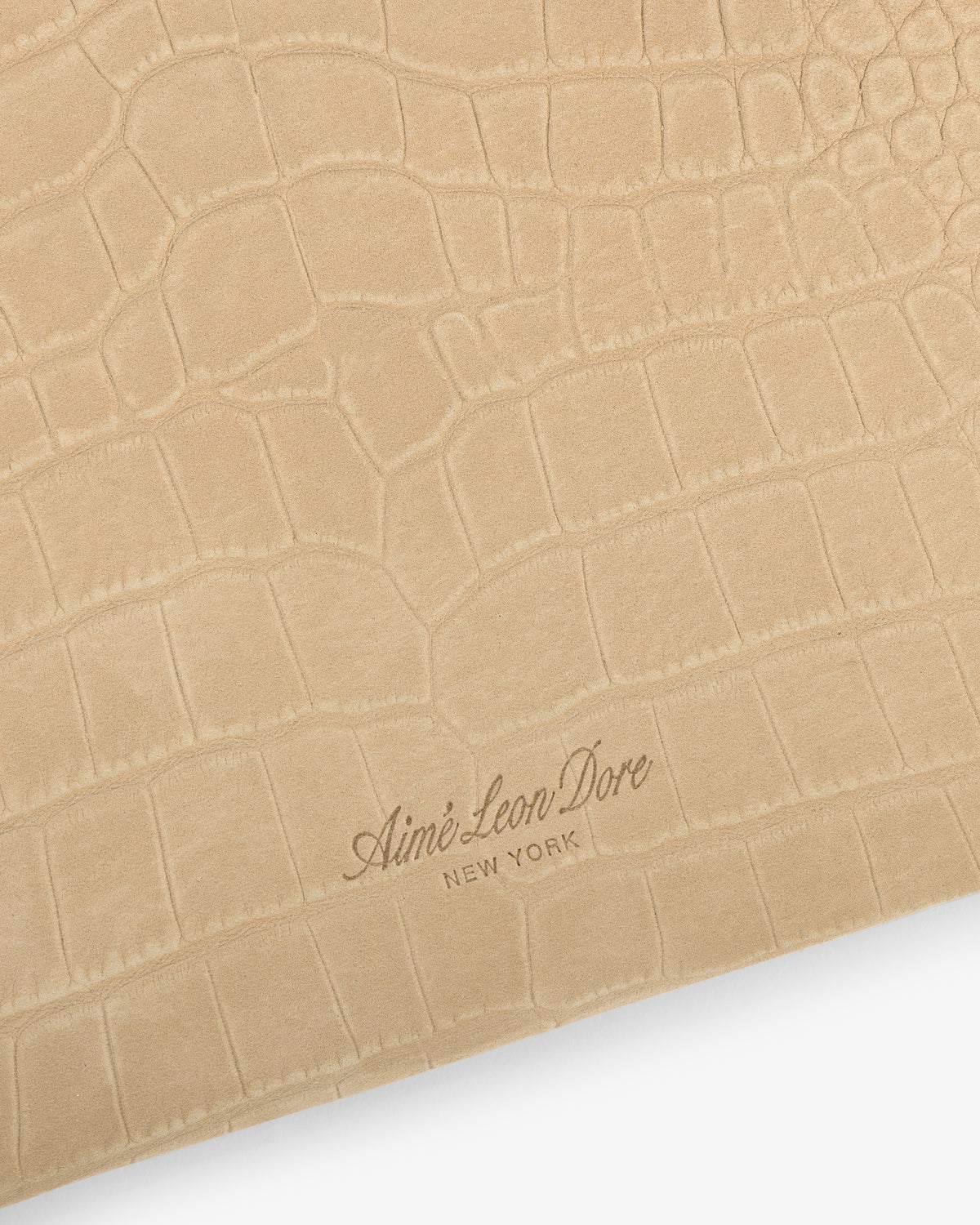 Small Croc-Embossed Nubuck Pouch featuring a tan faux-croc texture and Aimé Leon Dore New York logo at the bottom.