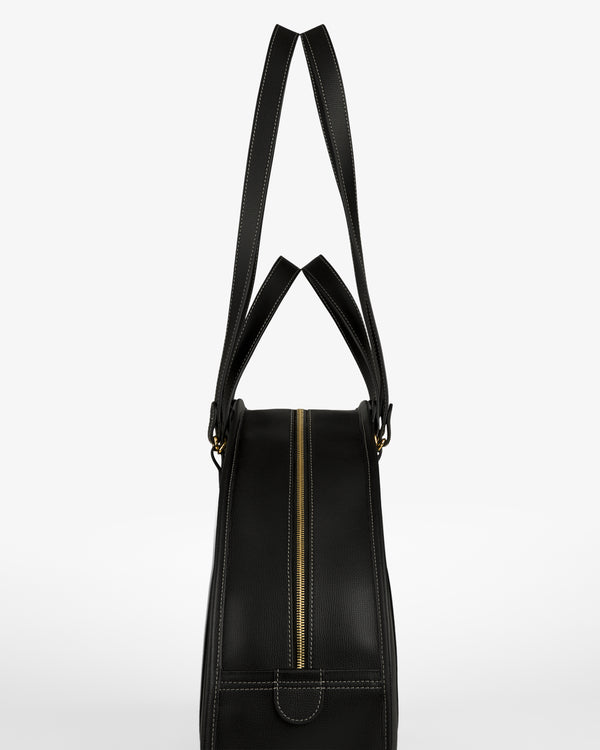 Full Grain Leather Weekender Bag in black, with gold zipper and double handles, shown side view on white background.