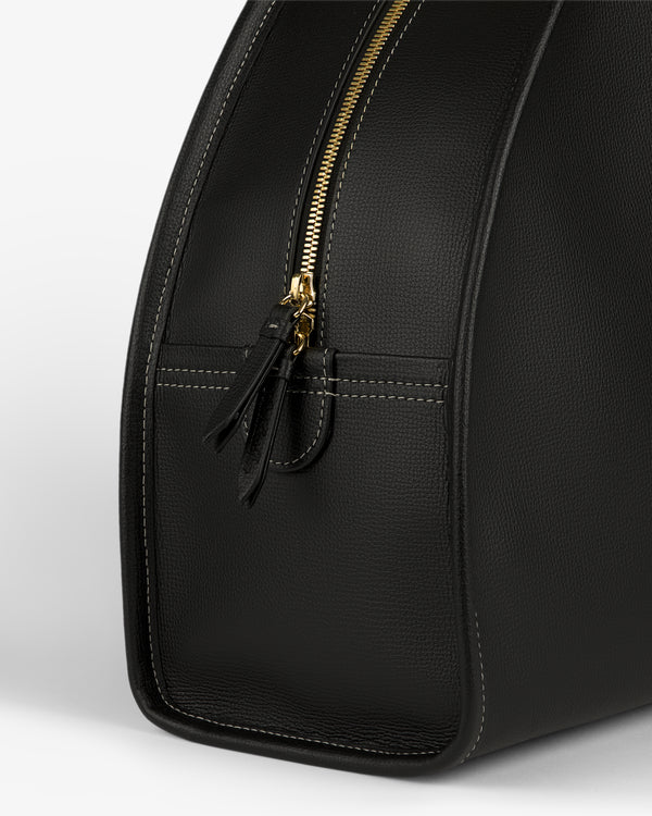 Close-up of the Full Grain Leather Weekender Bag in black with a gold zipper and visible side stitching.