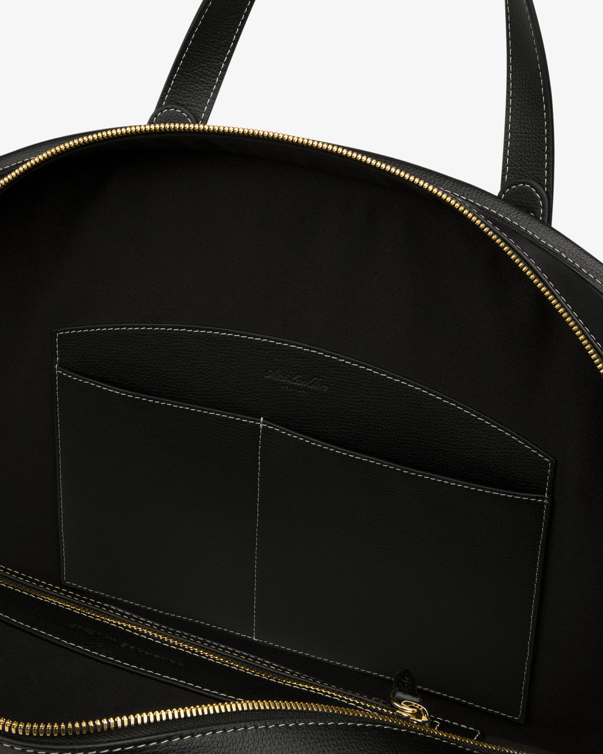 Open Full Grain Leather Weekender Bag with gold zipper, showing interior pocket and black lining on white background.