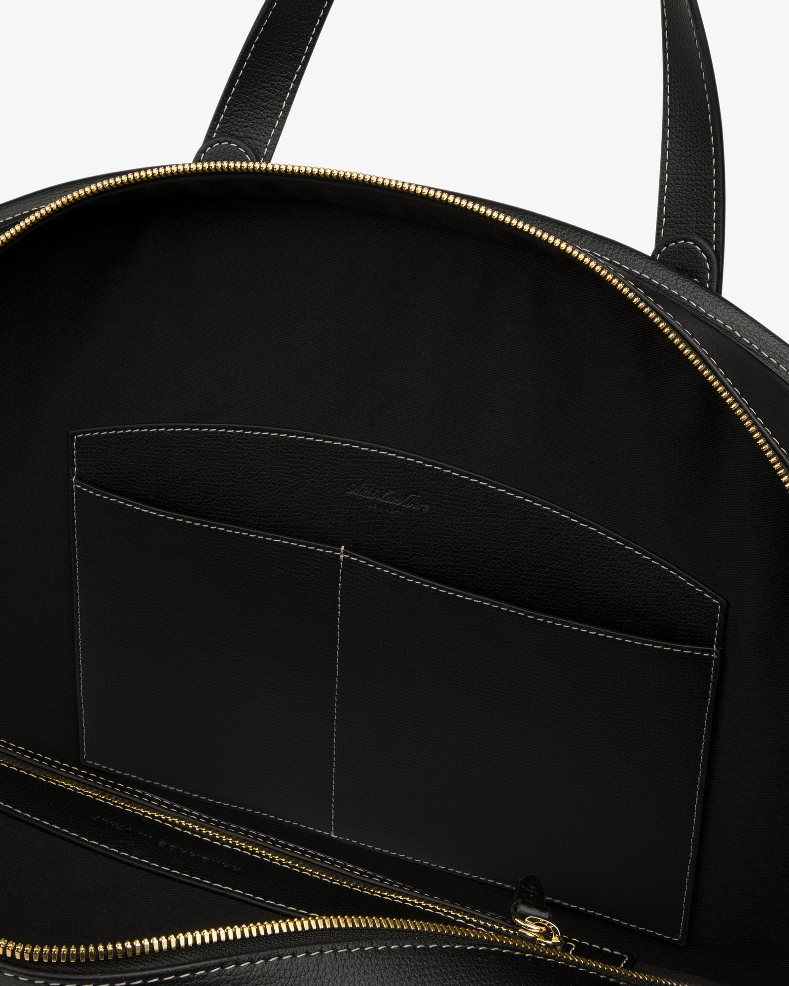 Open Full Grain Leather Weekender Bag with gold zipper, showing interior pocket and black lining on white background.