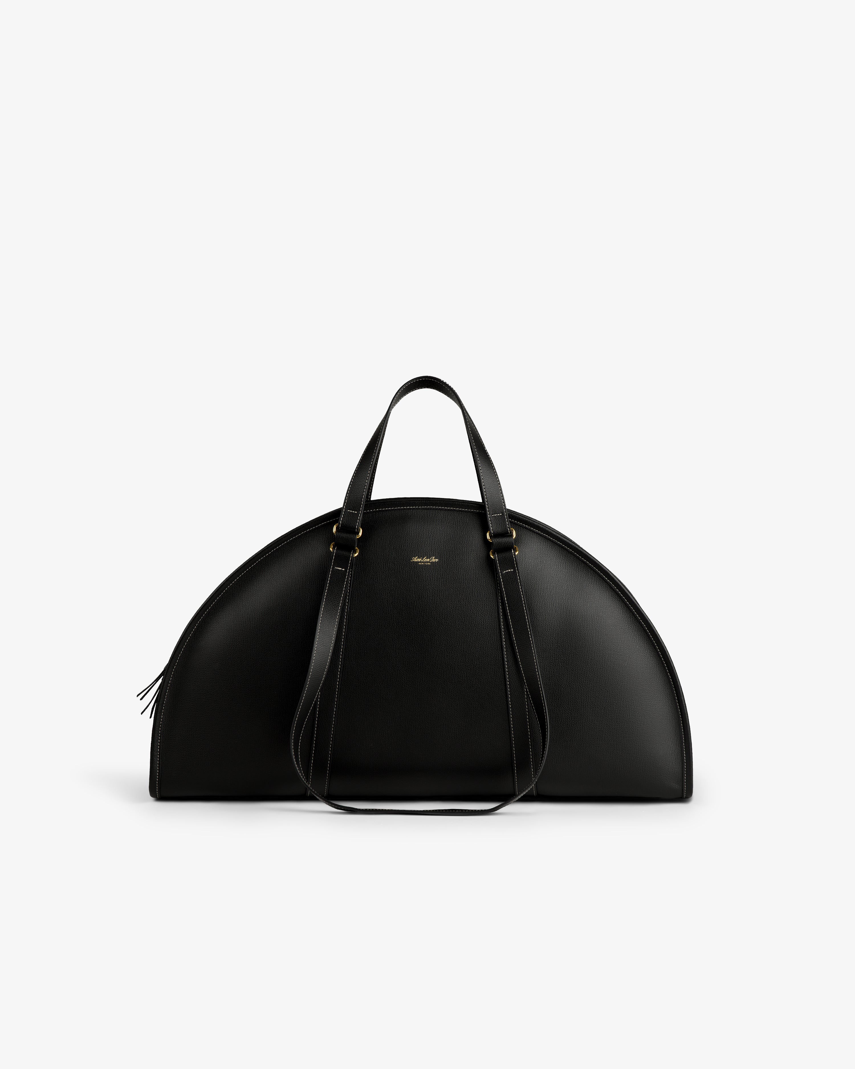 The Full Grain Leather Weekender Bag is black, semi-circular, with two top handles and shoulder straps.