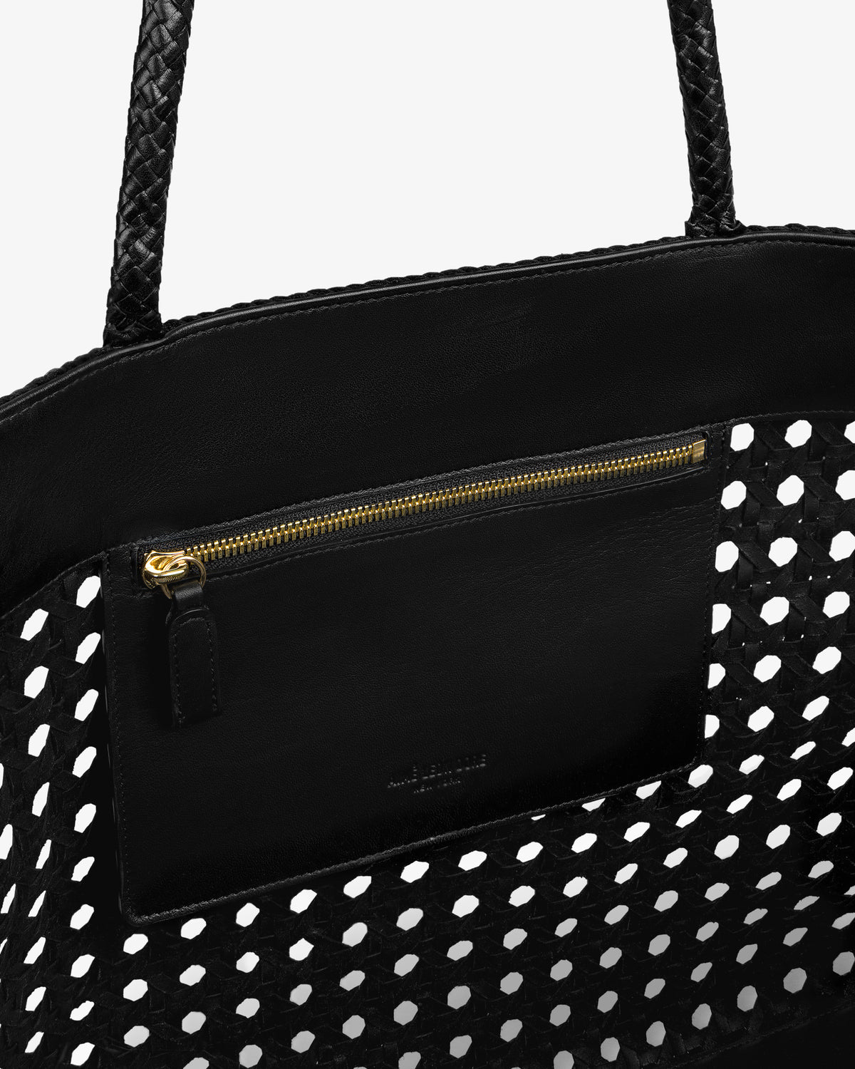 Close-up of the Woven Leather Tote Bag in black with a gold-zippered inner pocket and perforated design.