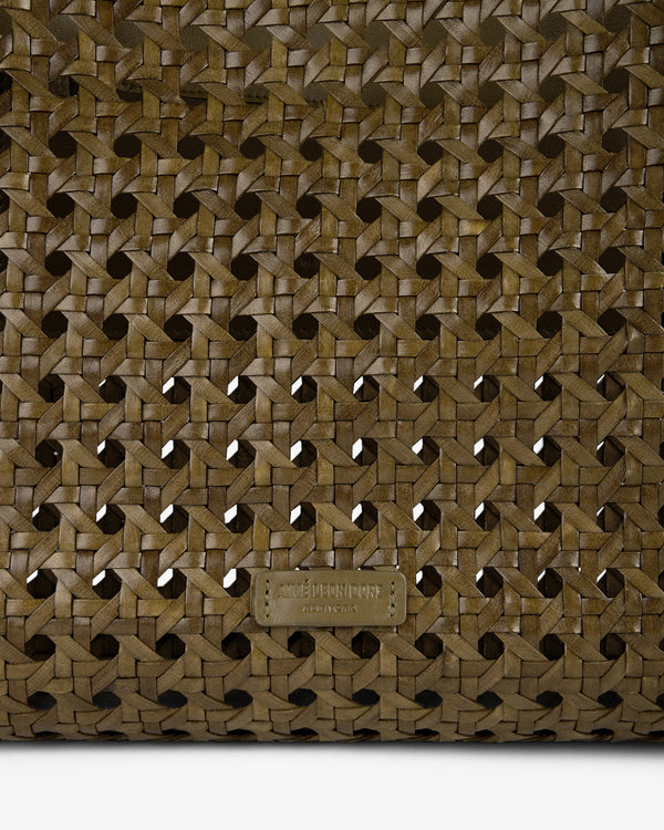 Close-up of the Woven Leather Tote Bag in brown with a small embossed rectangular label at the bottom center.