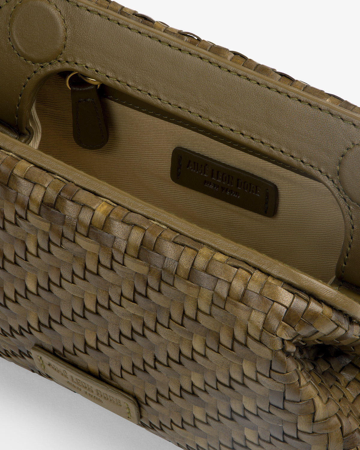 Close-up of an open Woven Leather Shoulder Bag with the embossed label and inner pocket visible.