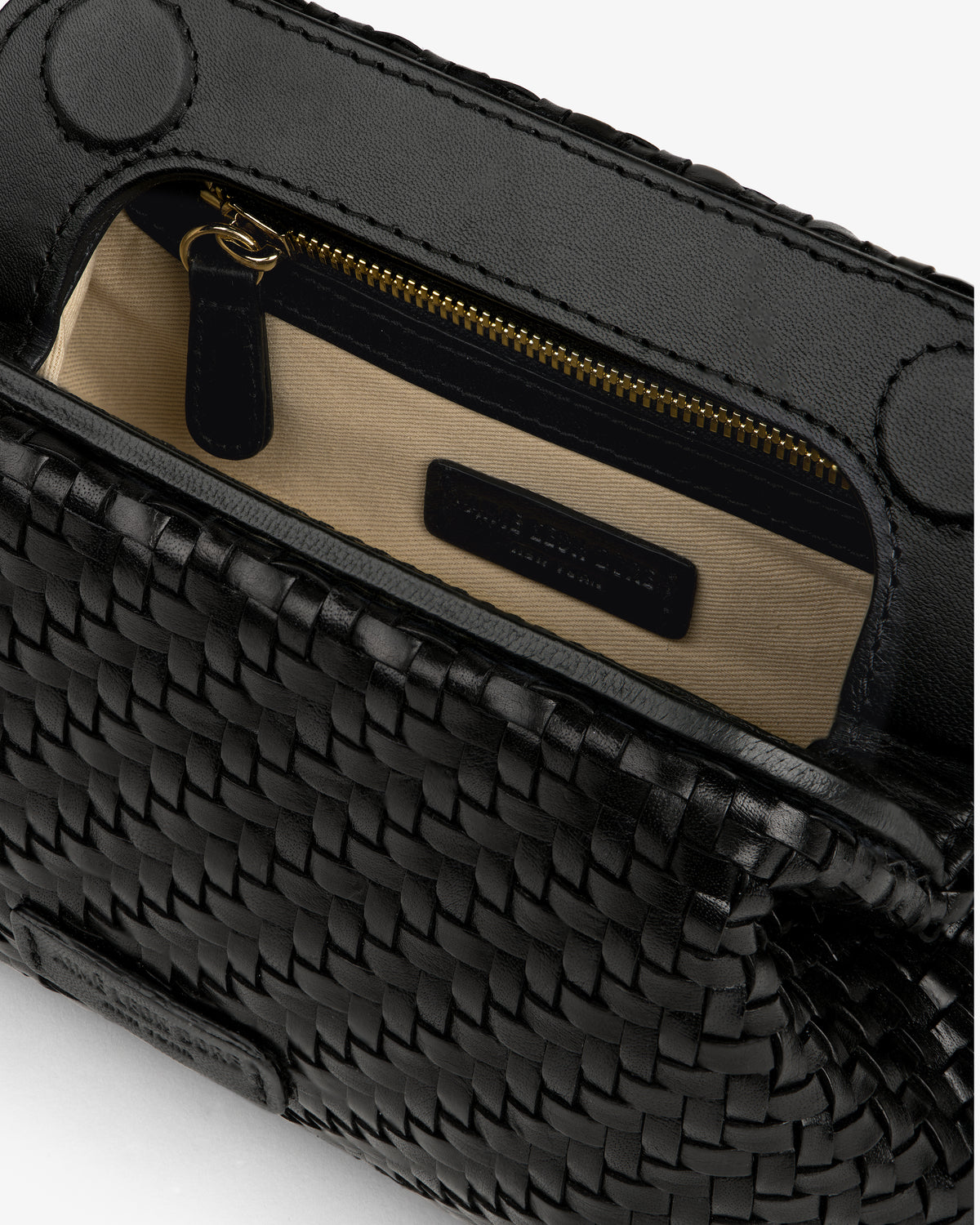 Close-up of the Woven Leather Shoulder Bag, open to show tan fabric lining and inner zippered pocket.