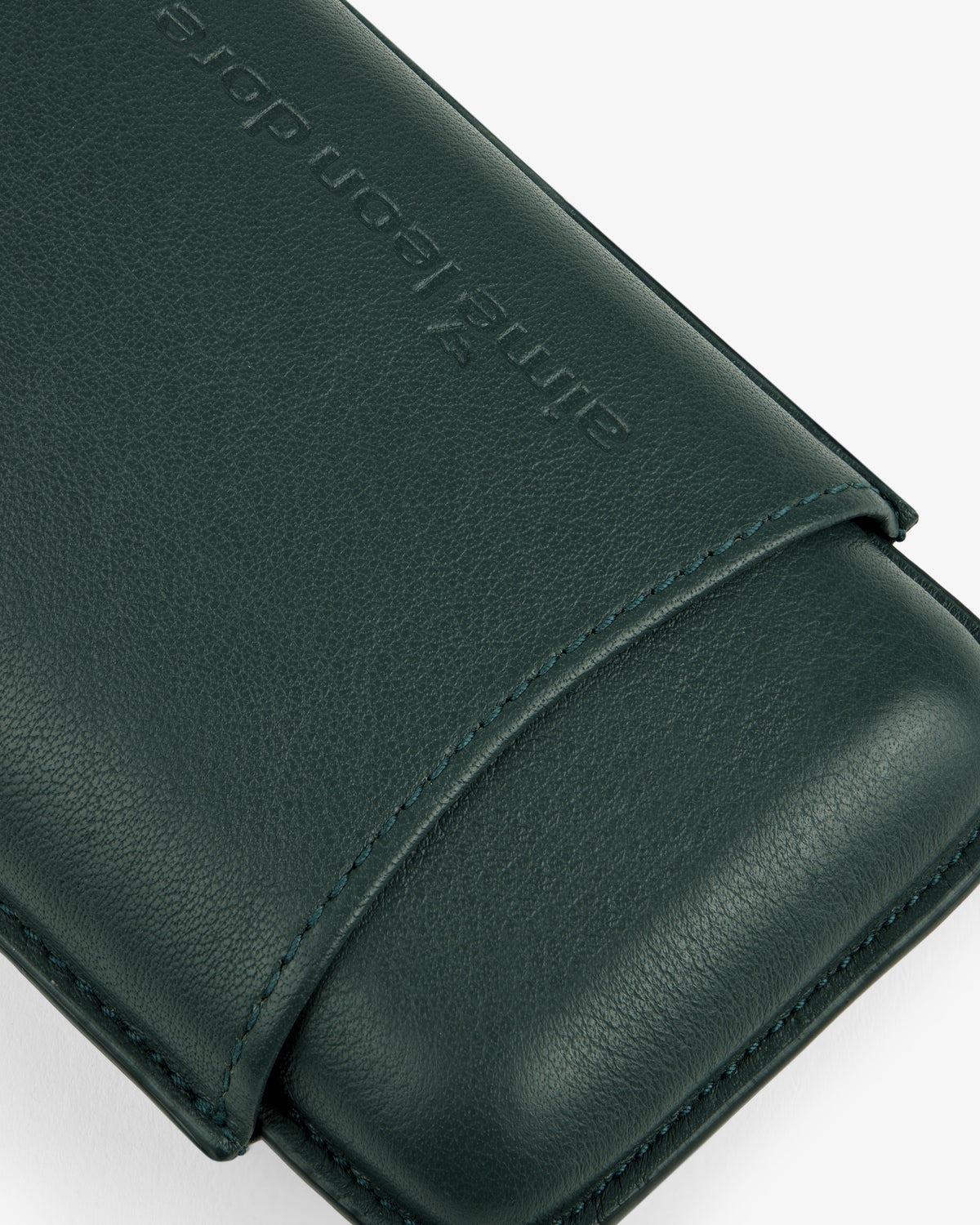 Close-up of the ALD Golf Leather Cigar Case in dark green, featuring embossed text against a light background.