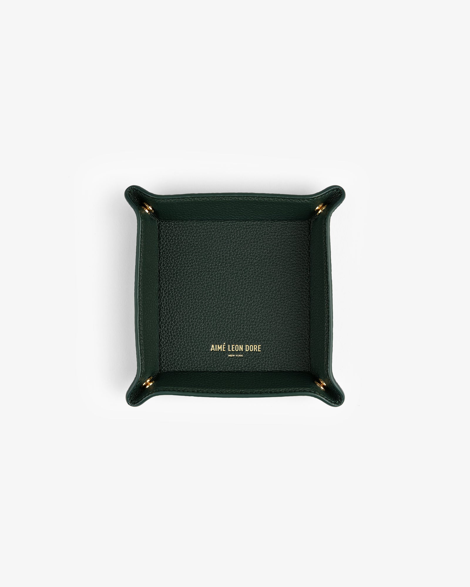 Dark green Leather Catchall with gold AIMÉ LEON DORE logo at center, photographed from above.