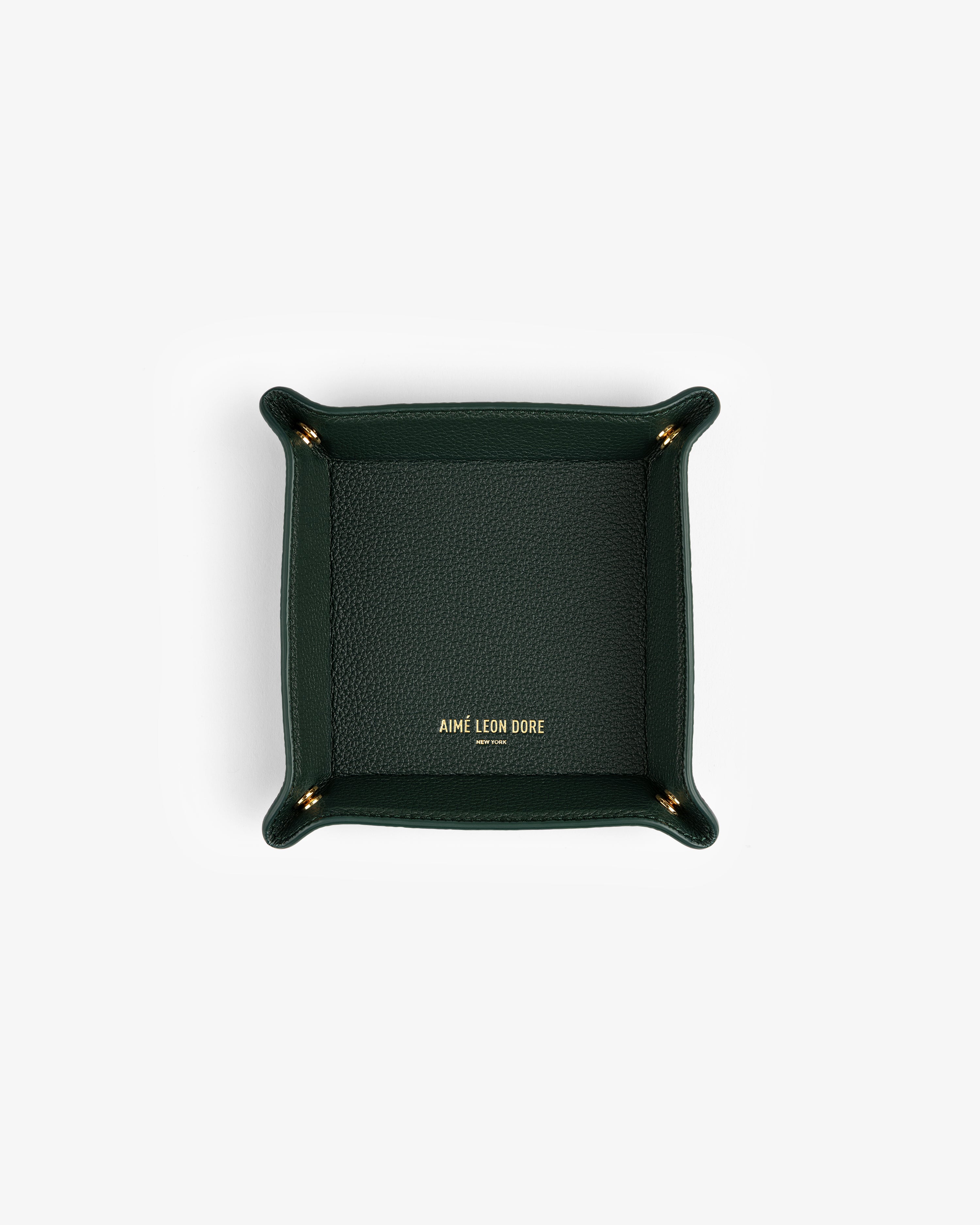 Dark green Leather Catchall with gold AIMÉ LEON DORE logo at center, photographed from above.