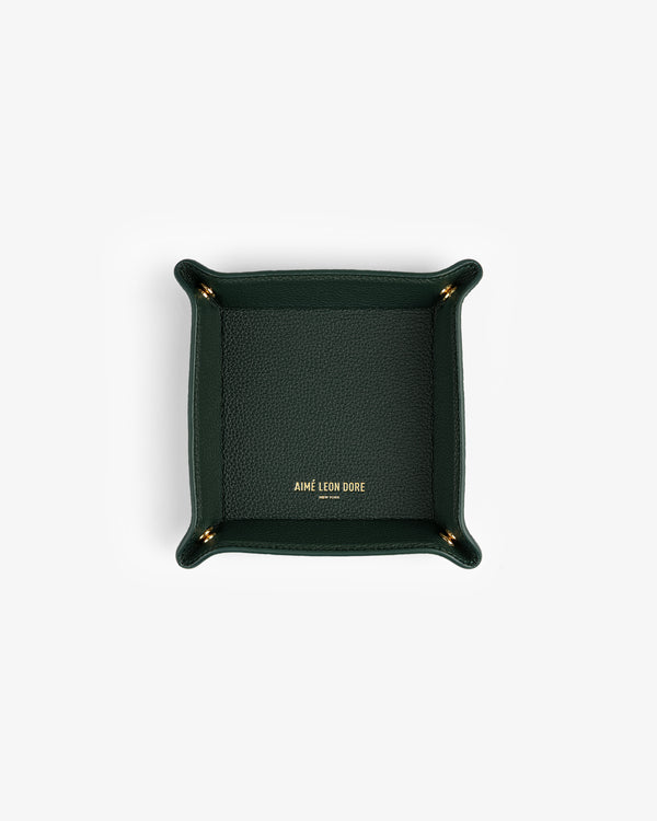 Dark green Leather Catchall with gold AIMÉ LEON DORE logo at center, photographed from above.