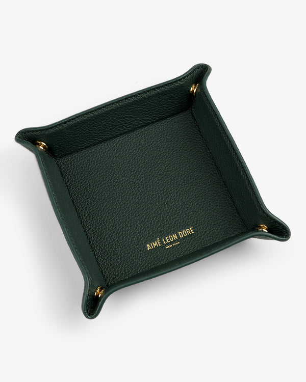 A dark green Leather Catchall with gold corner snaps and AIMÉ LEON DORE embossed in gold inside.