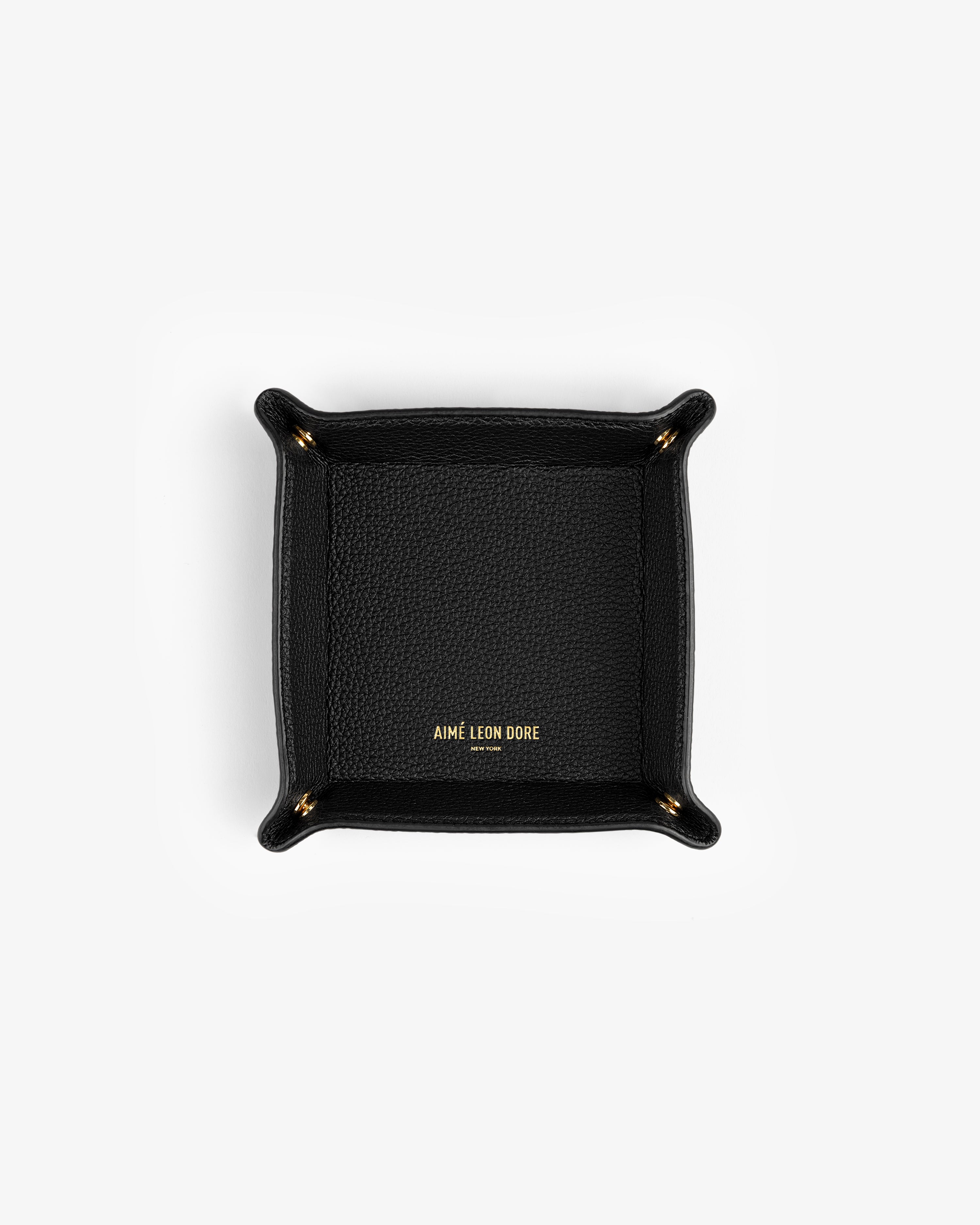 Black Leather Catchall with gold AIMÉ LEON DORE text in the center, shown from above on a white background.