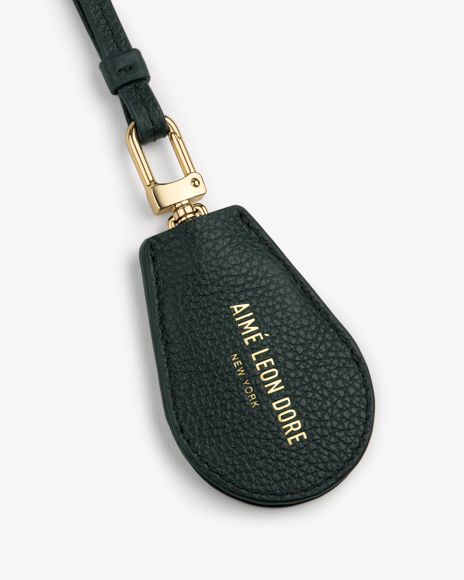 A black Leather Key Cover with gold hardware and AIMÉ LEON DORE NEW YORK printed in gold lettering.